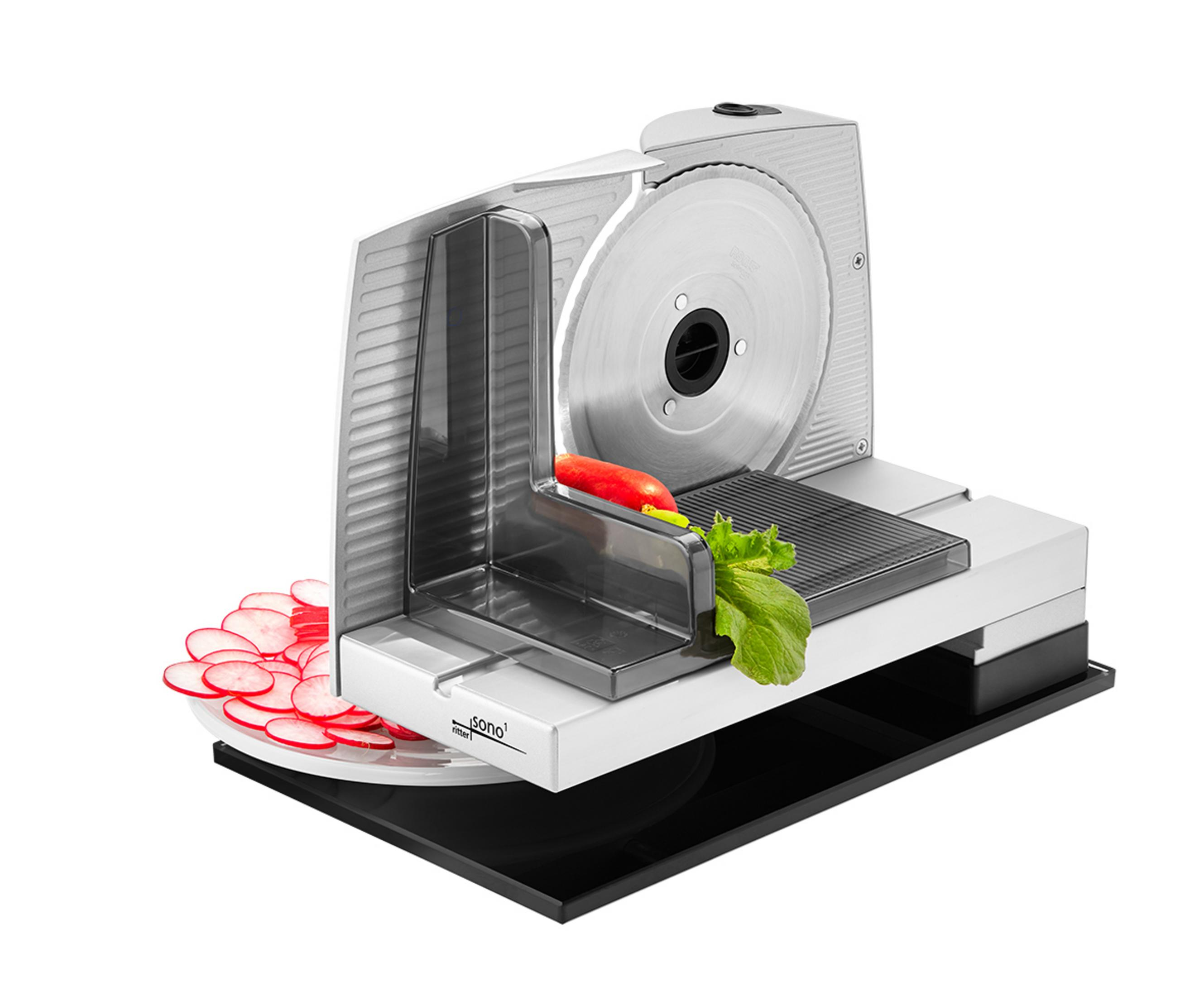 Krajalnica do mięsa z plasterkami rzodkiewki i czerwoną papryką. Krajalnica jest srebrna.