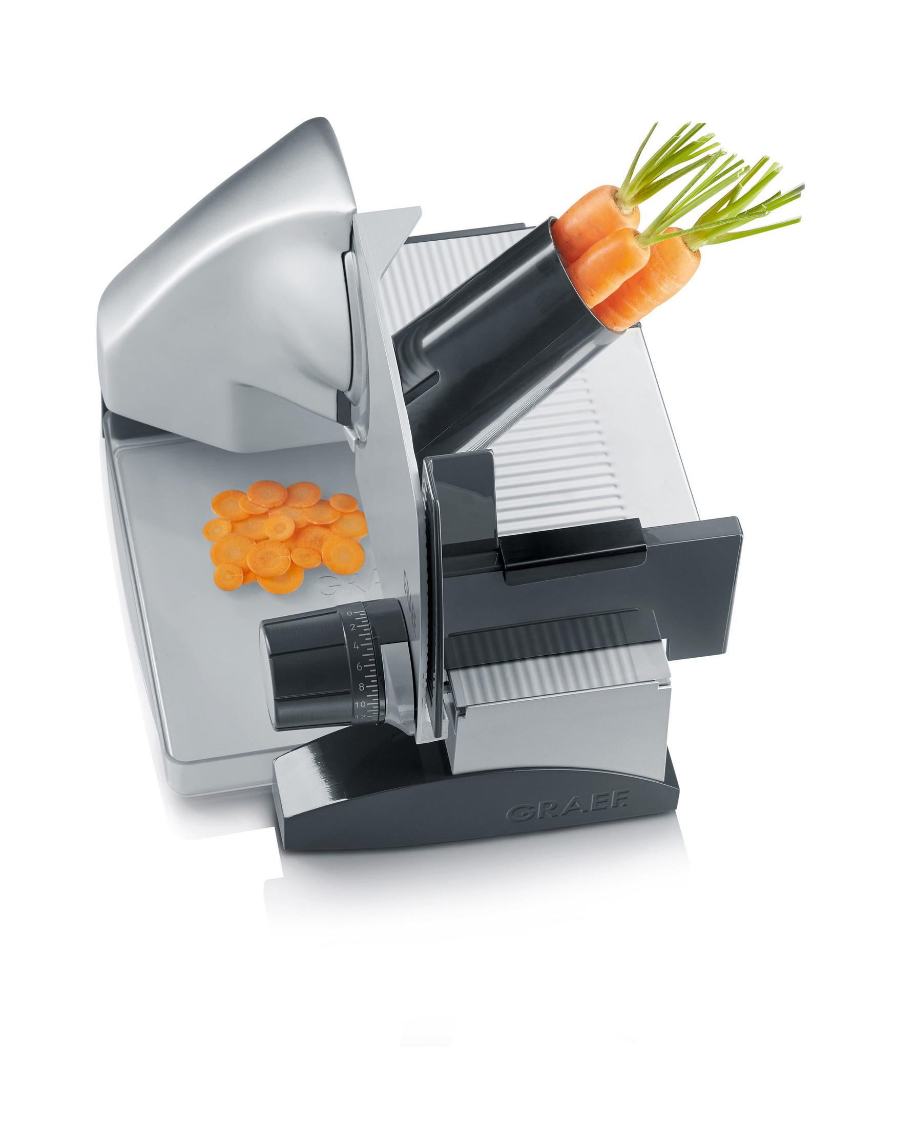 Srebrna i czarna krajalnica do żywności, z marchewką w podajniku i pokrojoną marchewką.