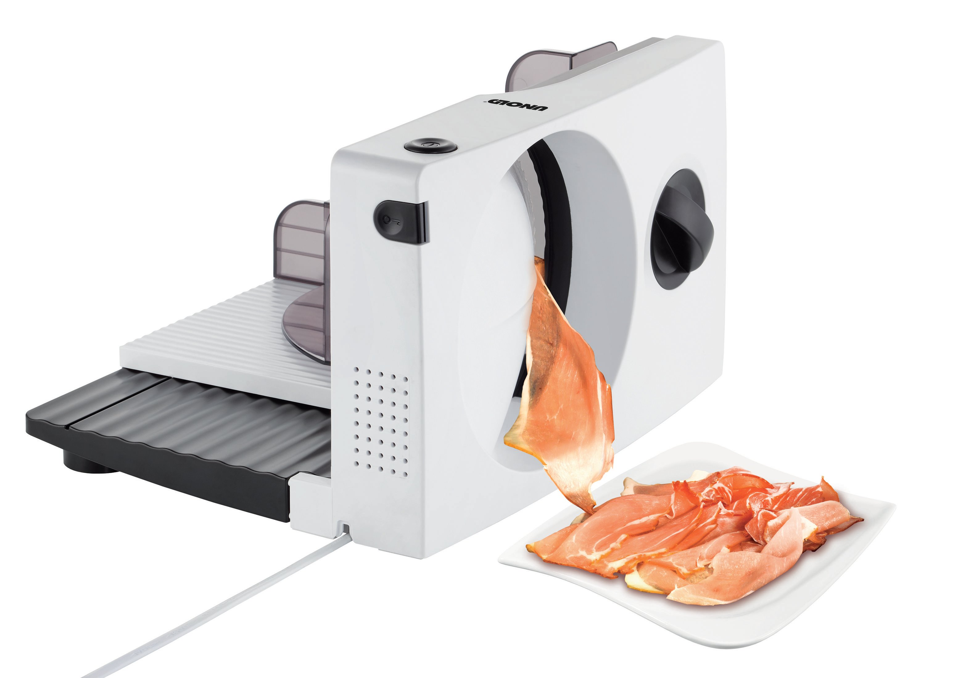 Biała krajalnica do mięsa z pokrojonym mięsem na talerzu. Białe tło.