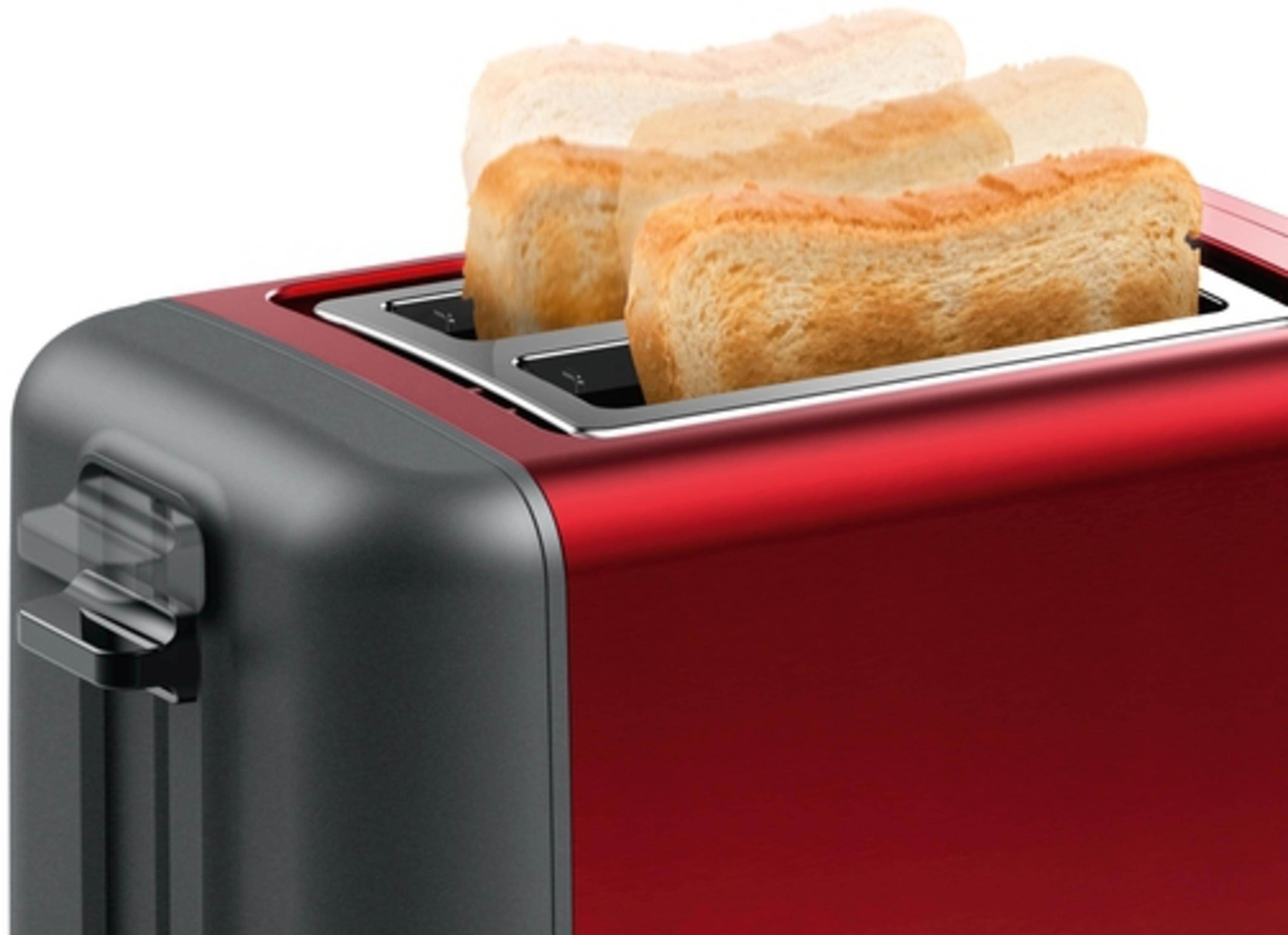 Czerwony toster z dwoma kawałkami chleba wyskakującymi. To ujęcie z bliska.