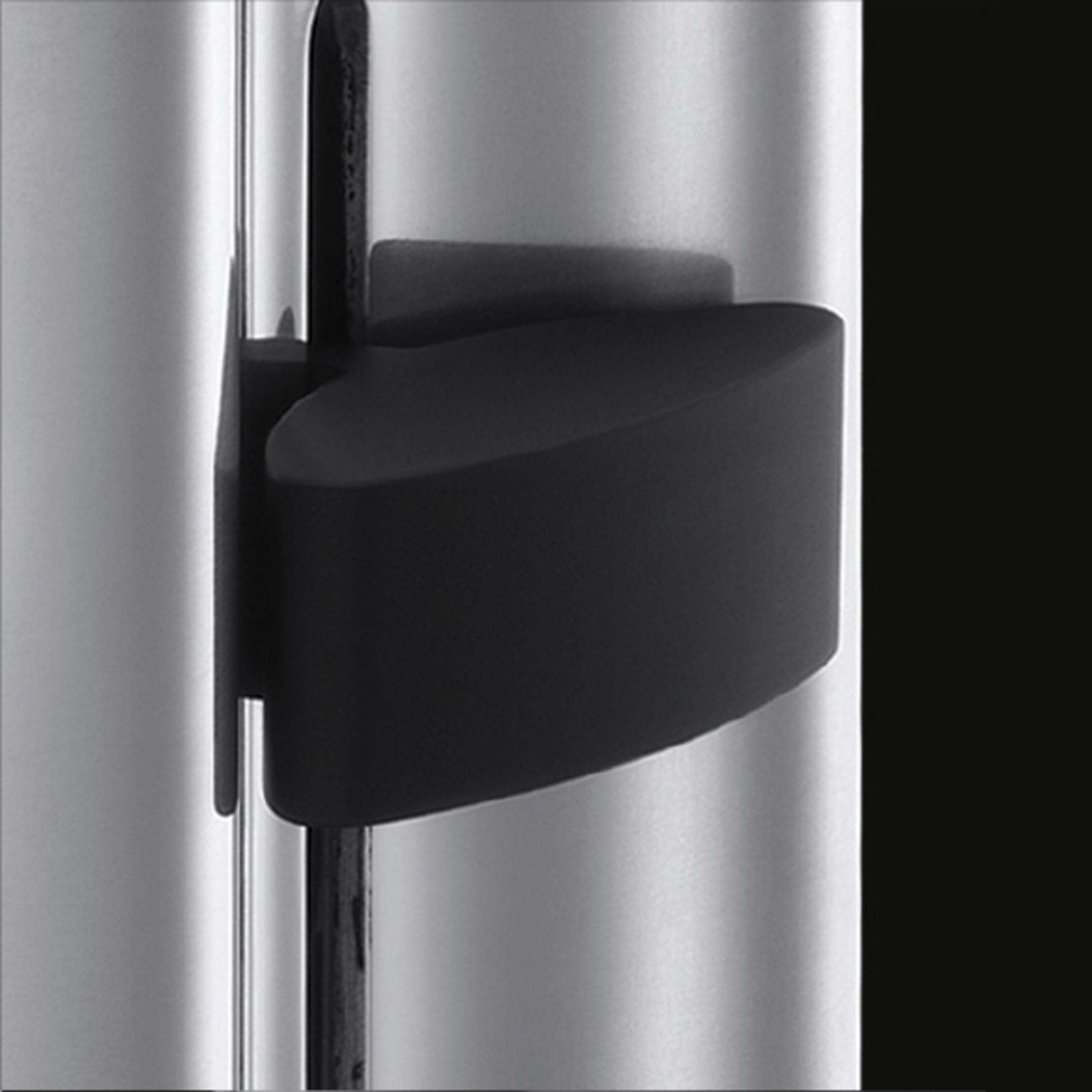 Nahaufnahme eines schwarzen Türgriffs auf einer silbernen Metalloberfläche.