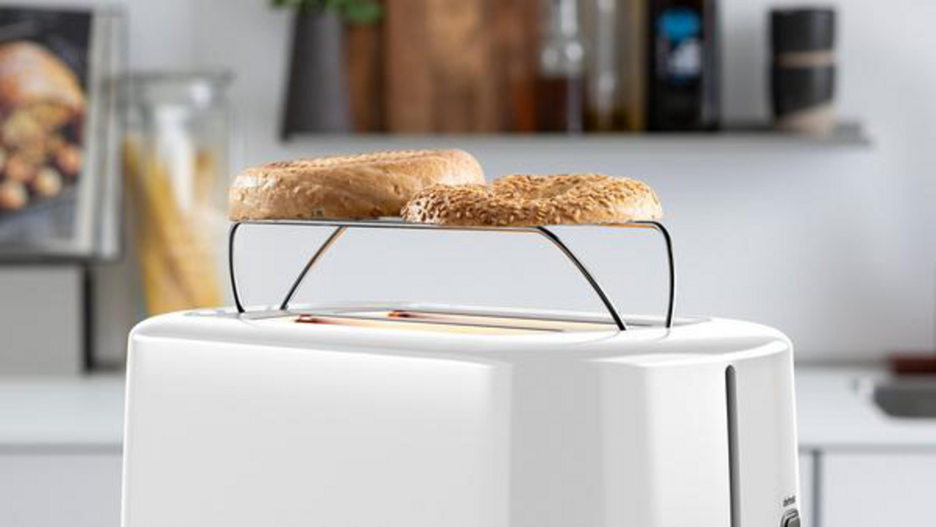 Un tostapane bianco con due bagel su una griglia. I bagel sono tostati sopra.