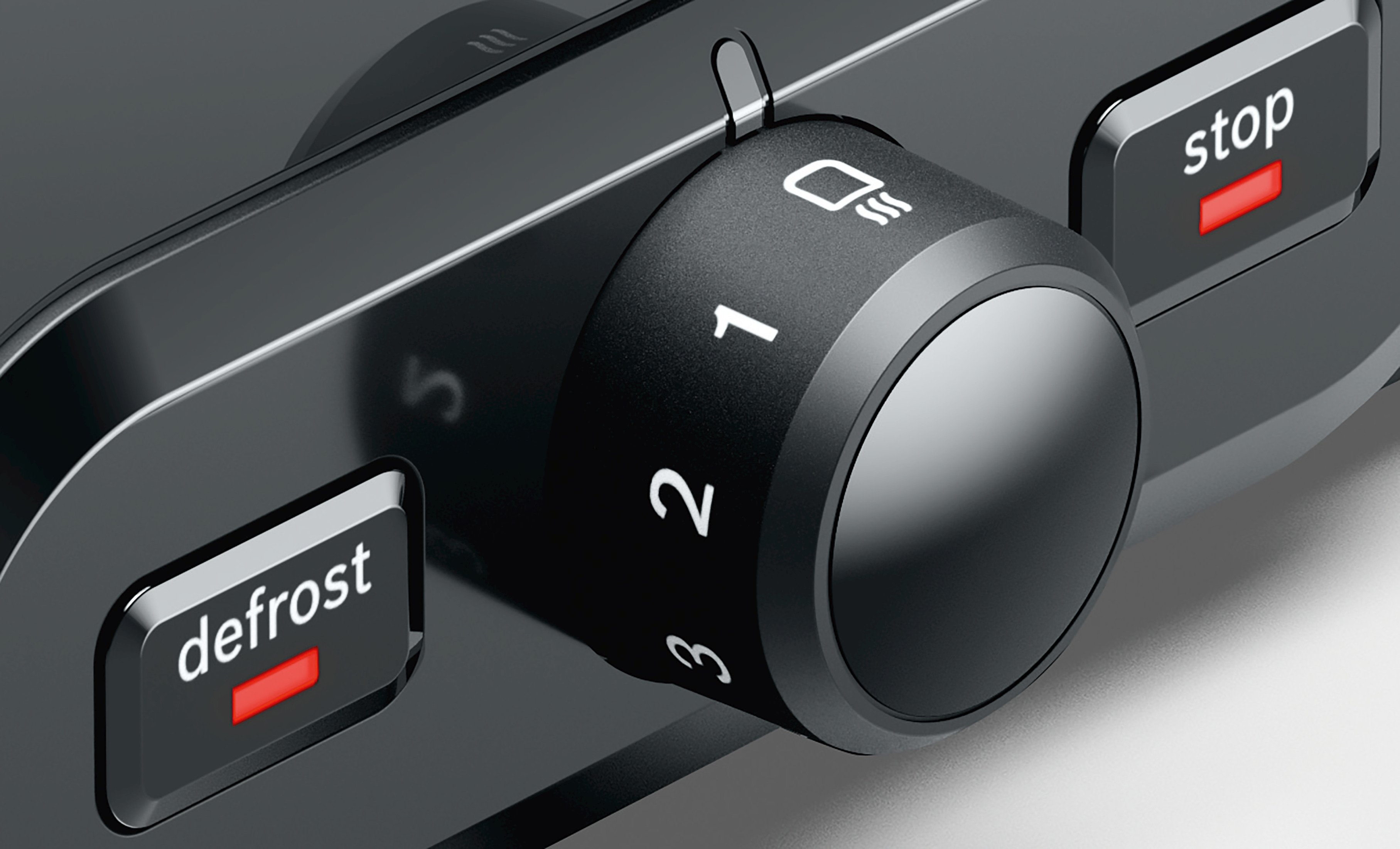 Zbliżenie czarnego tostera z pokrętłem i podświetlanymi na czerwono przyciskami 'defrost' i 'stop'.