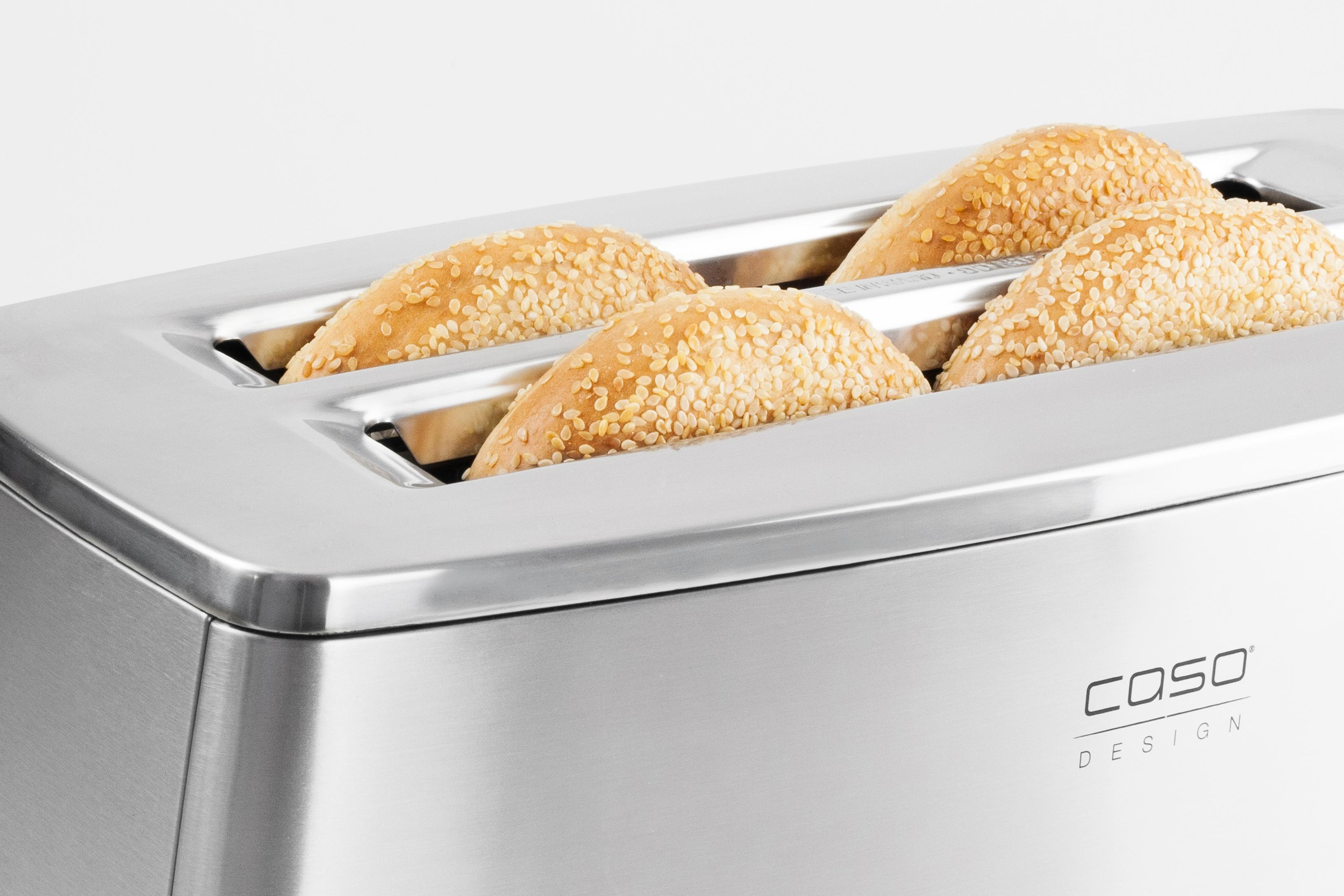 Cuatro bollos de semillas de sésamo en una tostadora de acero inoxidable. La palabra COSO está impresa en el lateral.