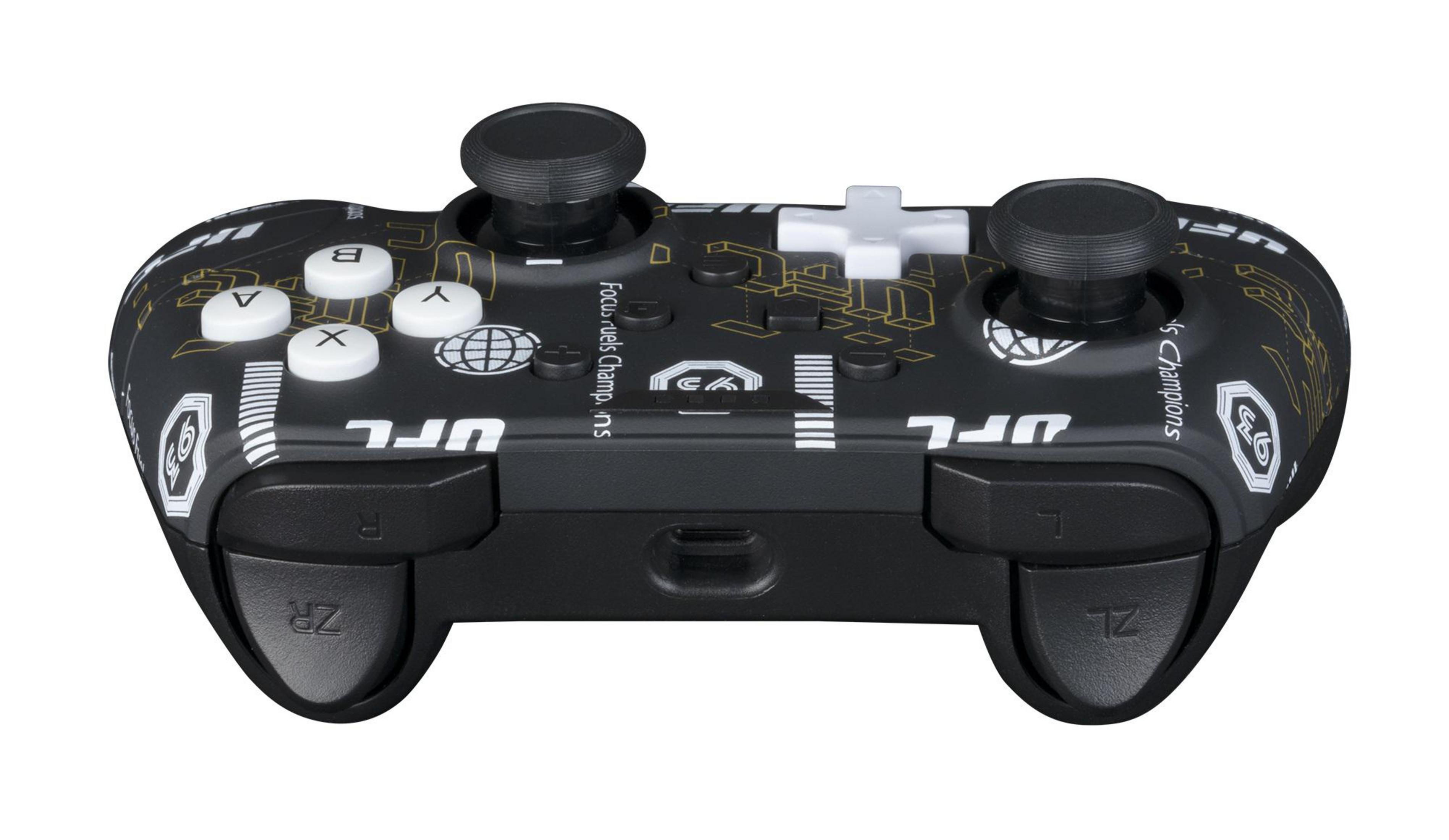 Controller di gioco nero con pulsanti bianchi e dettagli dorati. Ha una croce e due joystick.