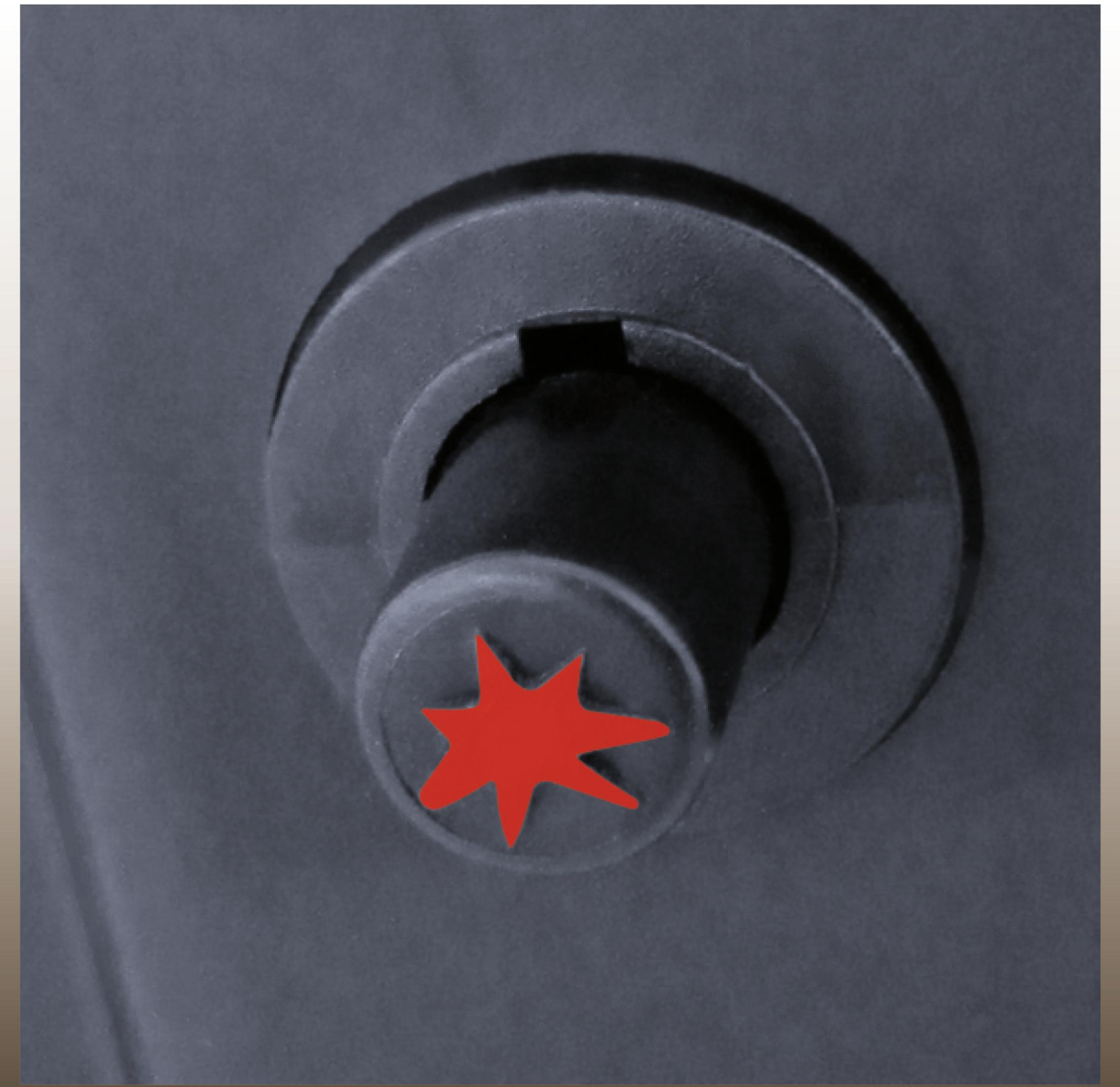 Manopola nera con stella rossa su superficie grigio scuro.