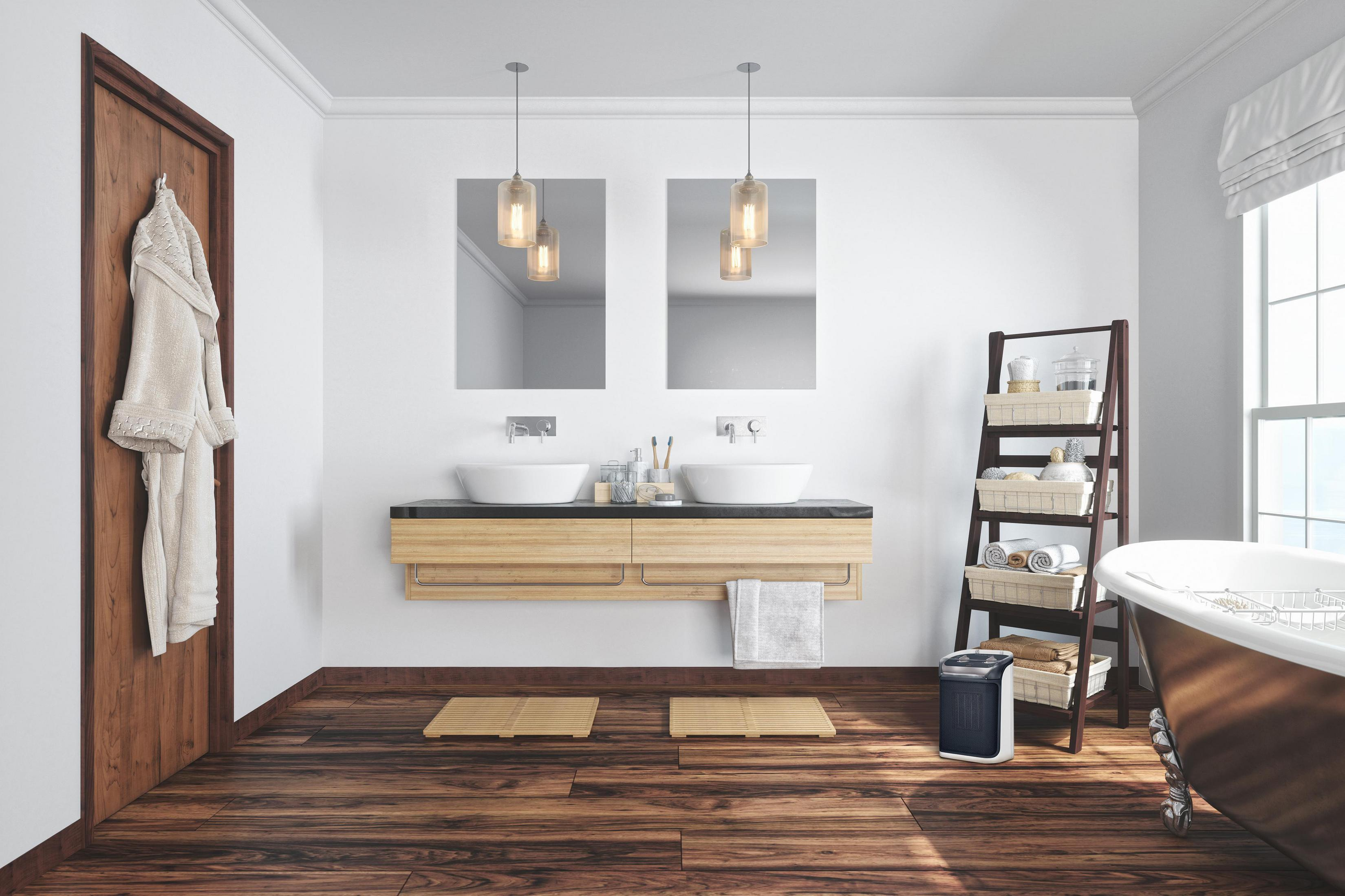 Łazienka z drewnianą podłogą, białymi ścianami, lustrami, umywalkami i wanną. Szlafrok wisi na drzwiach.