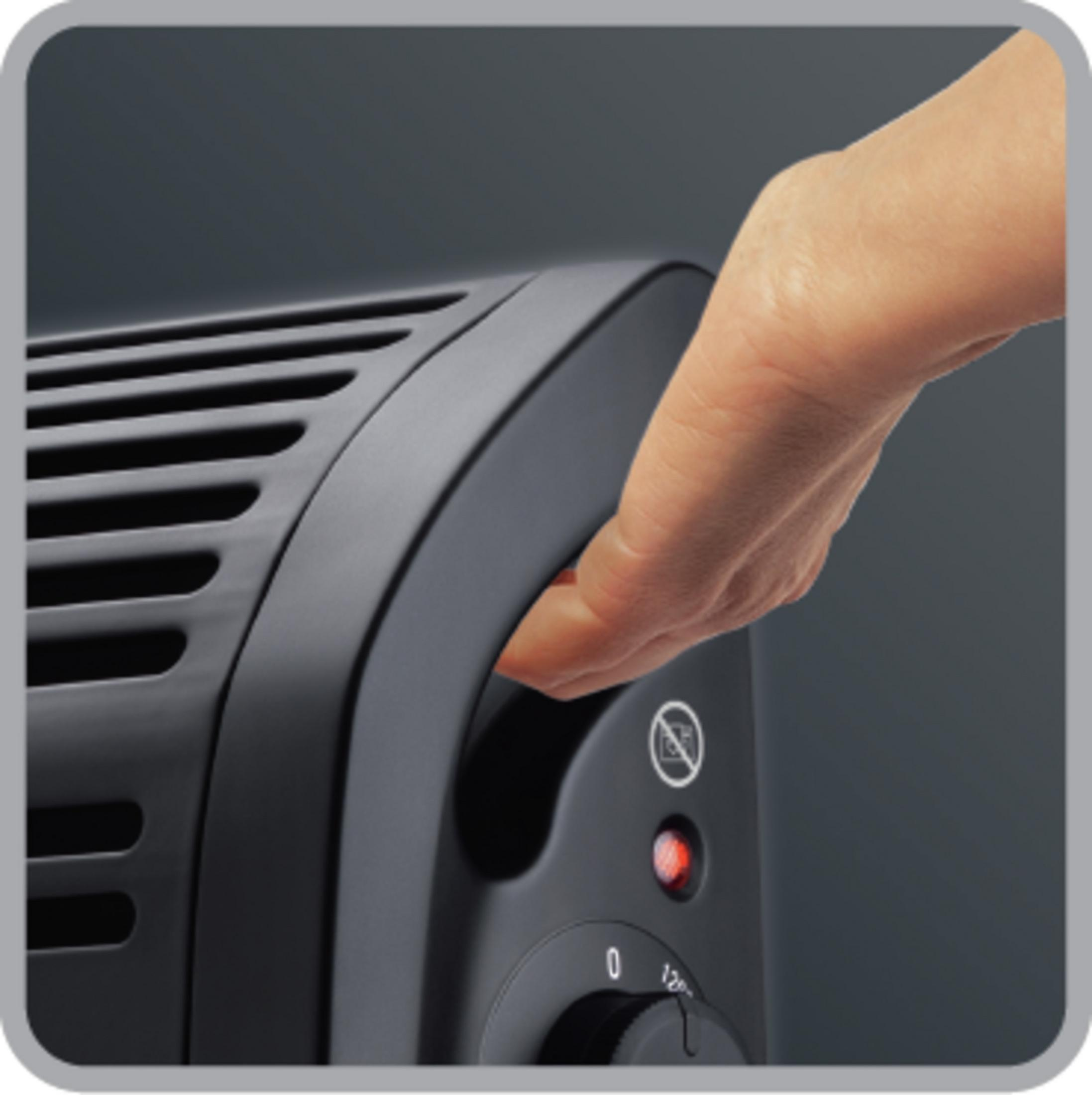 Zbliżenie czarnego grzejnika. Ręka sięga po uchwyt. Świeci się czerwone światło.