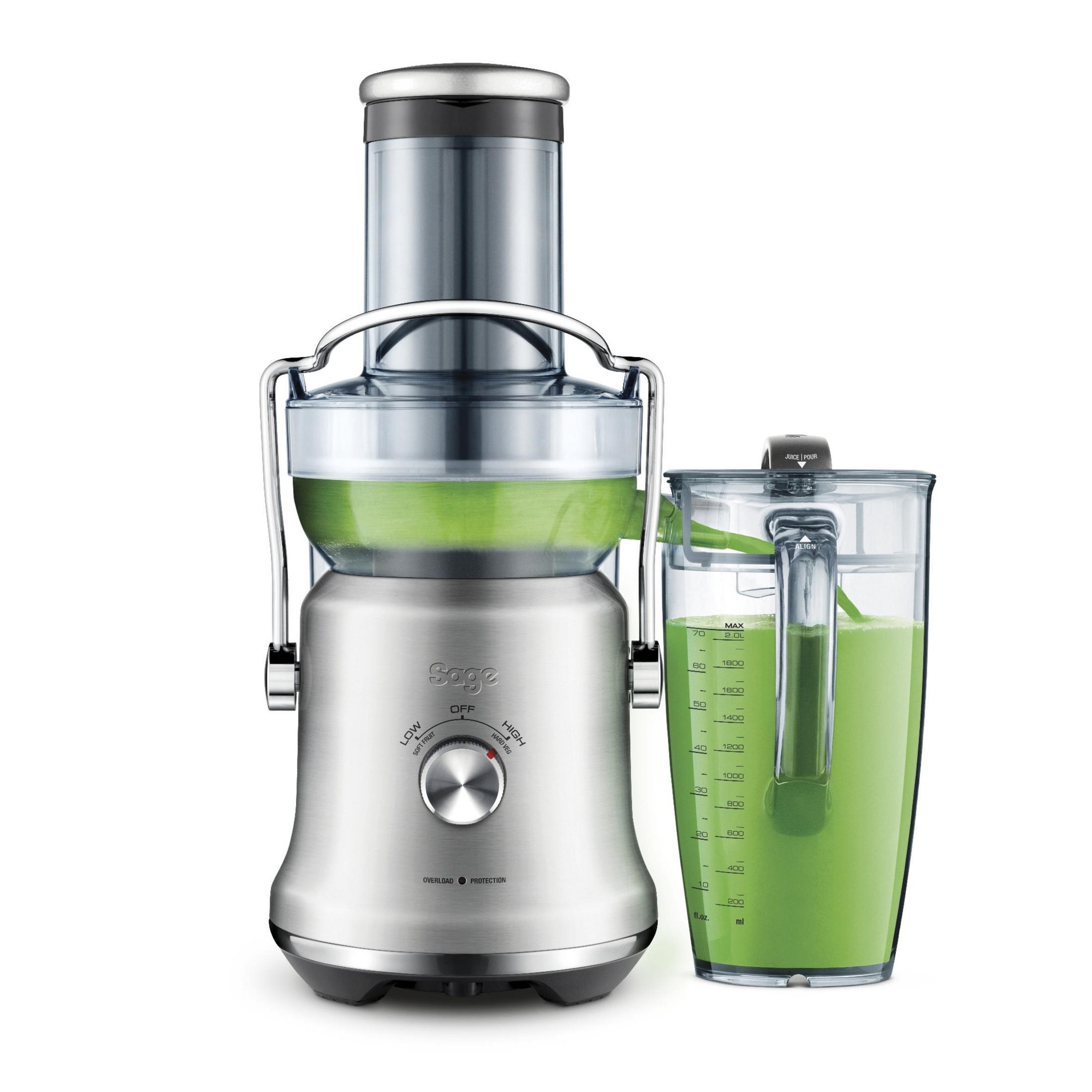 Centrifuga argentata con succo verde e una brocca piena di succo verde. Sfondo bianco.