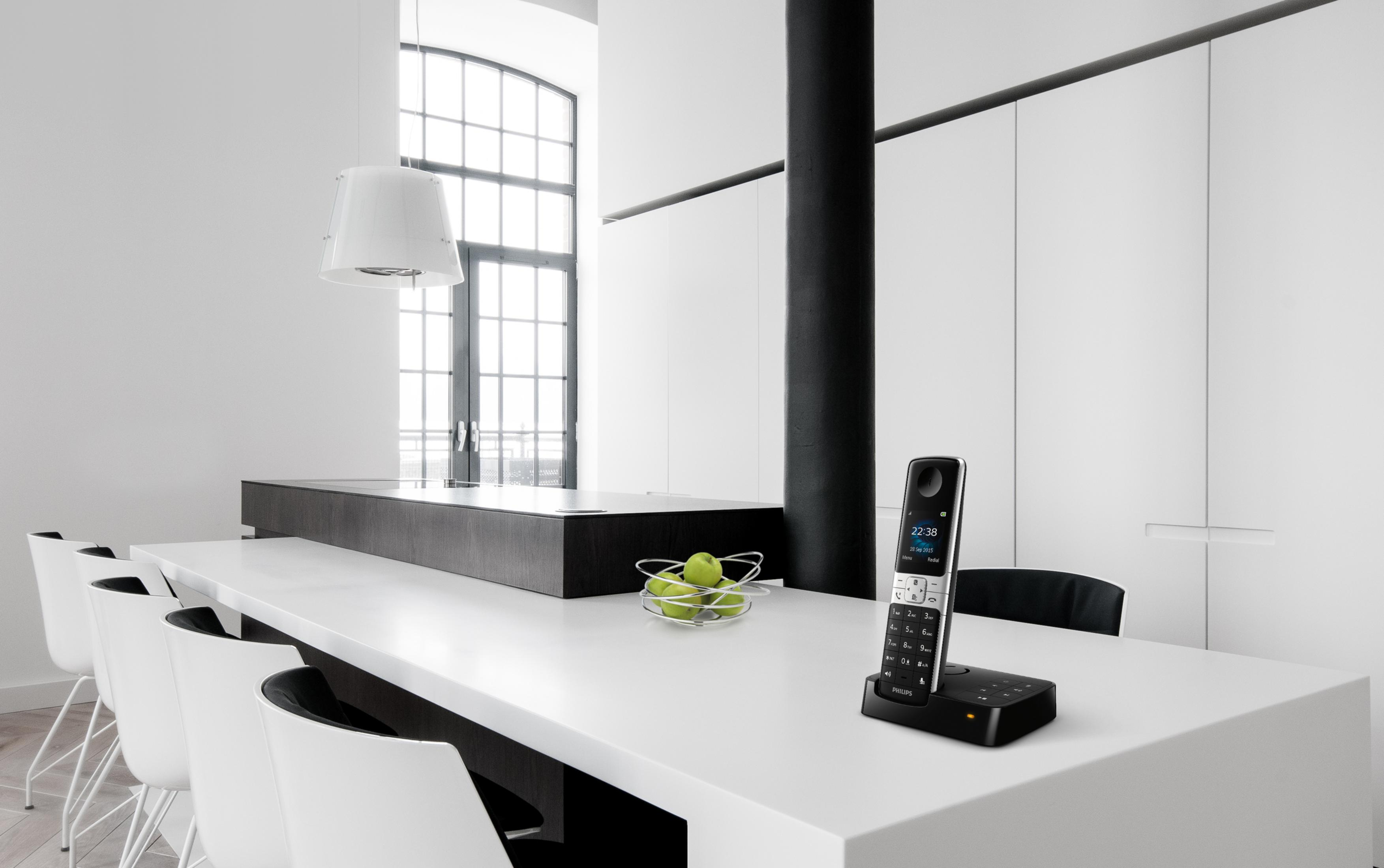 Cuisine moderne avec un téléphone sans fil sur un comptoir blanc, avec un fond blanc.