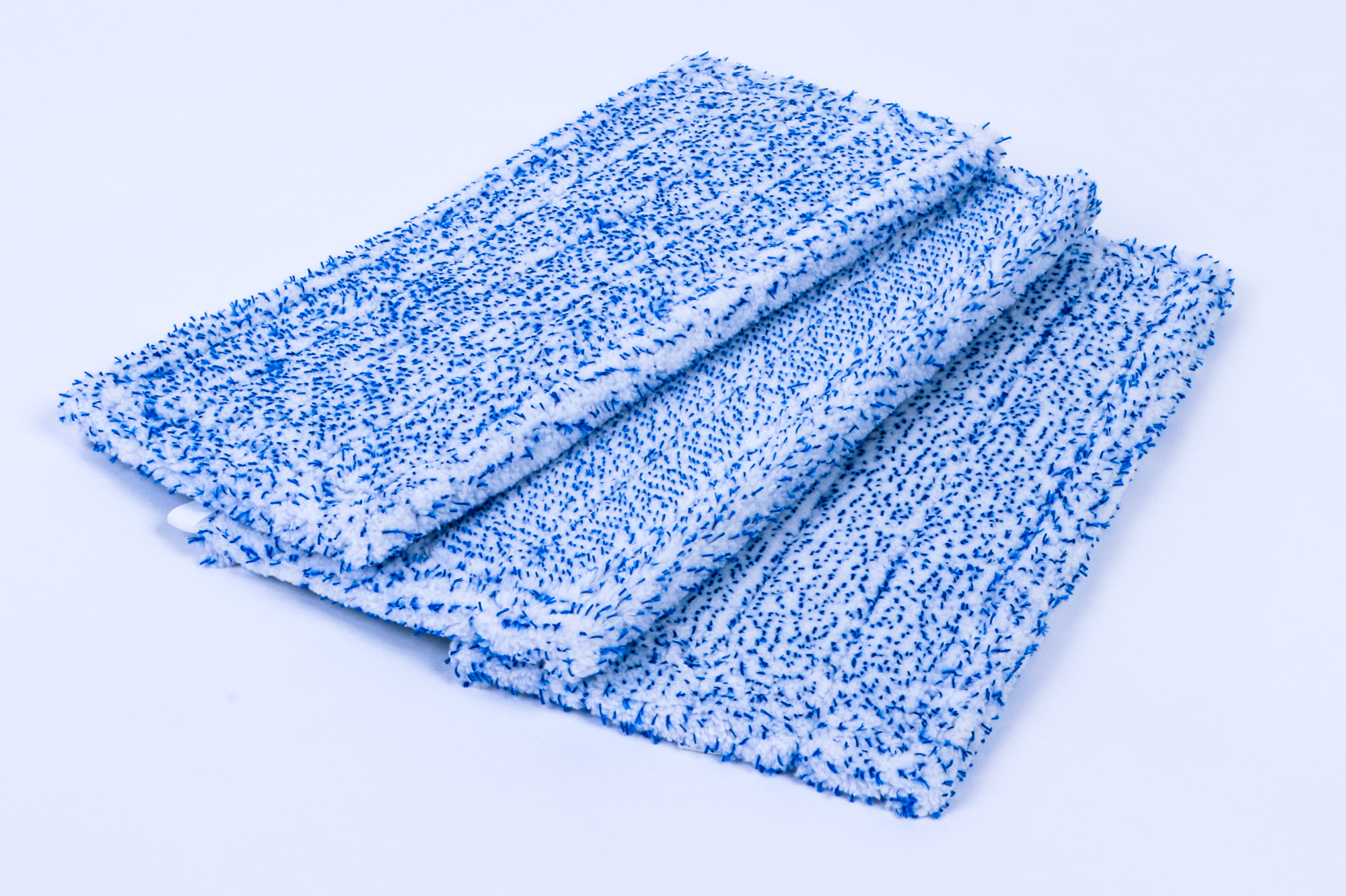 Drei blaue und weiße Mopp-Pads sind auf einer weißen Oberfläche gestapelt.