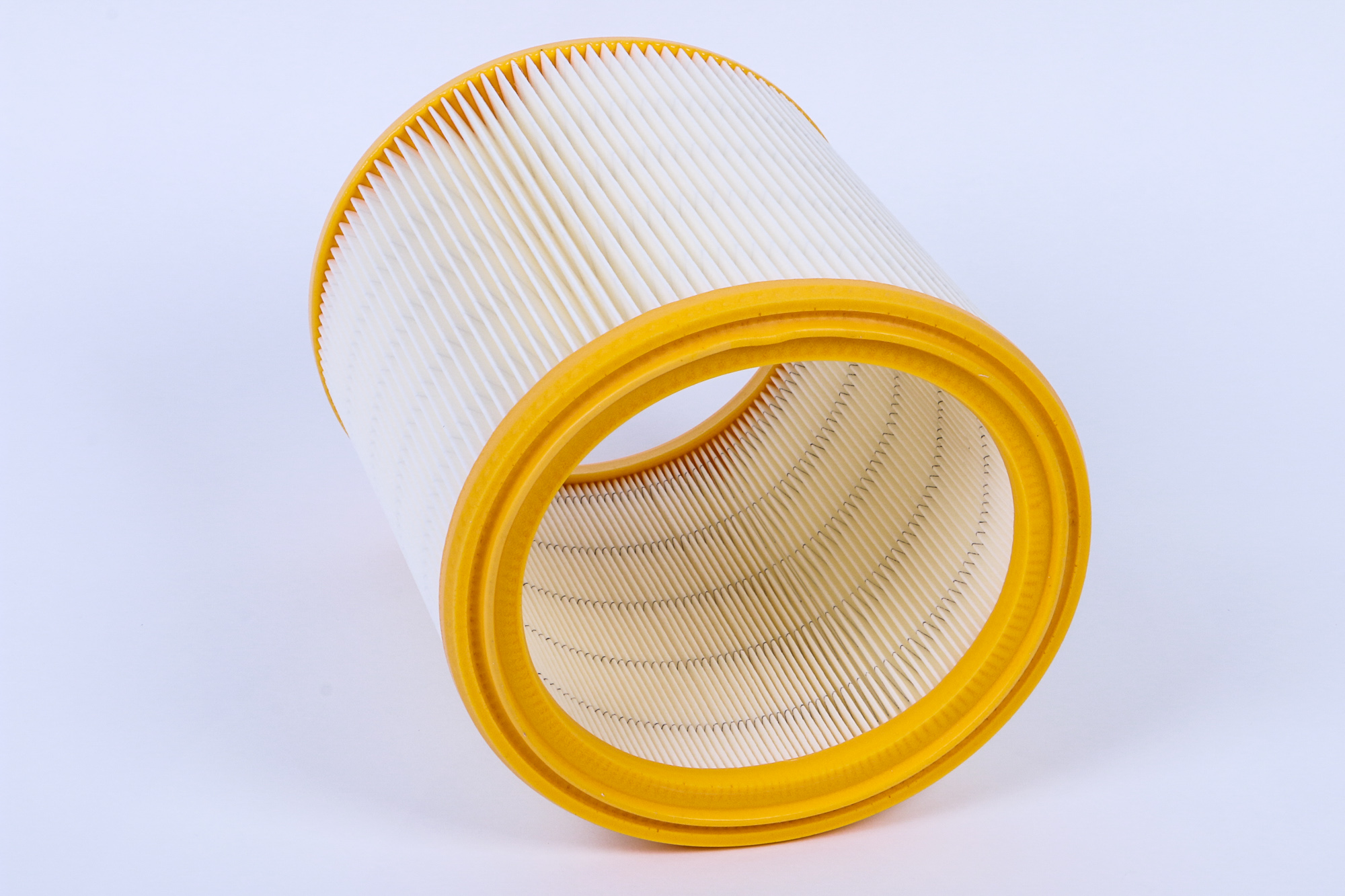 Zylindrischer Luftfilter mit gelbem Rahmen. Der Filter ist weiß und hat viele Falten.