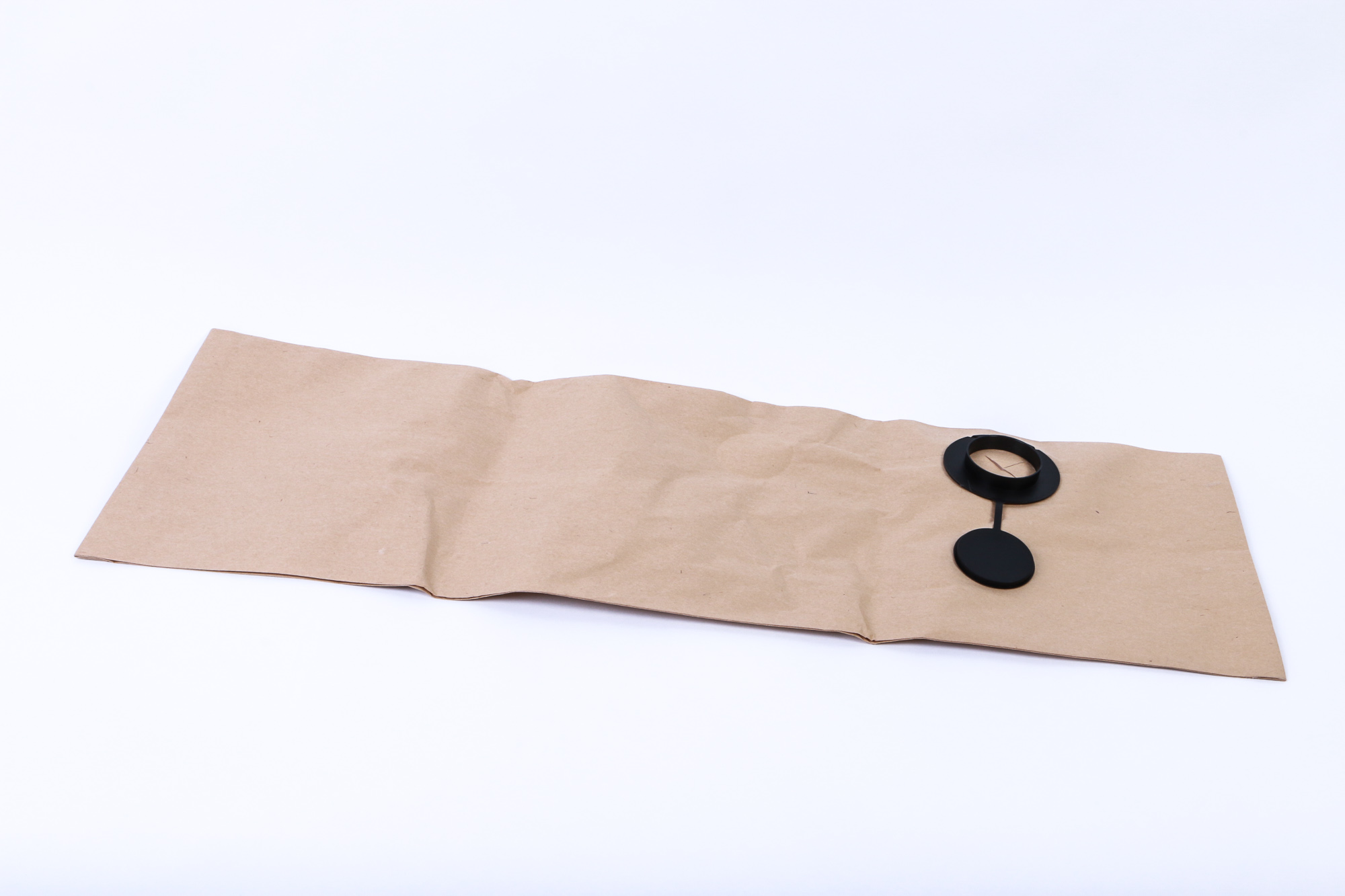 Ein braunes Papierpaket mit einem schwarzen Objekt und einem daran befestigten schwarzen Ring.
