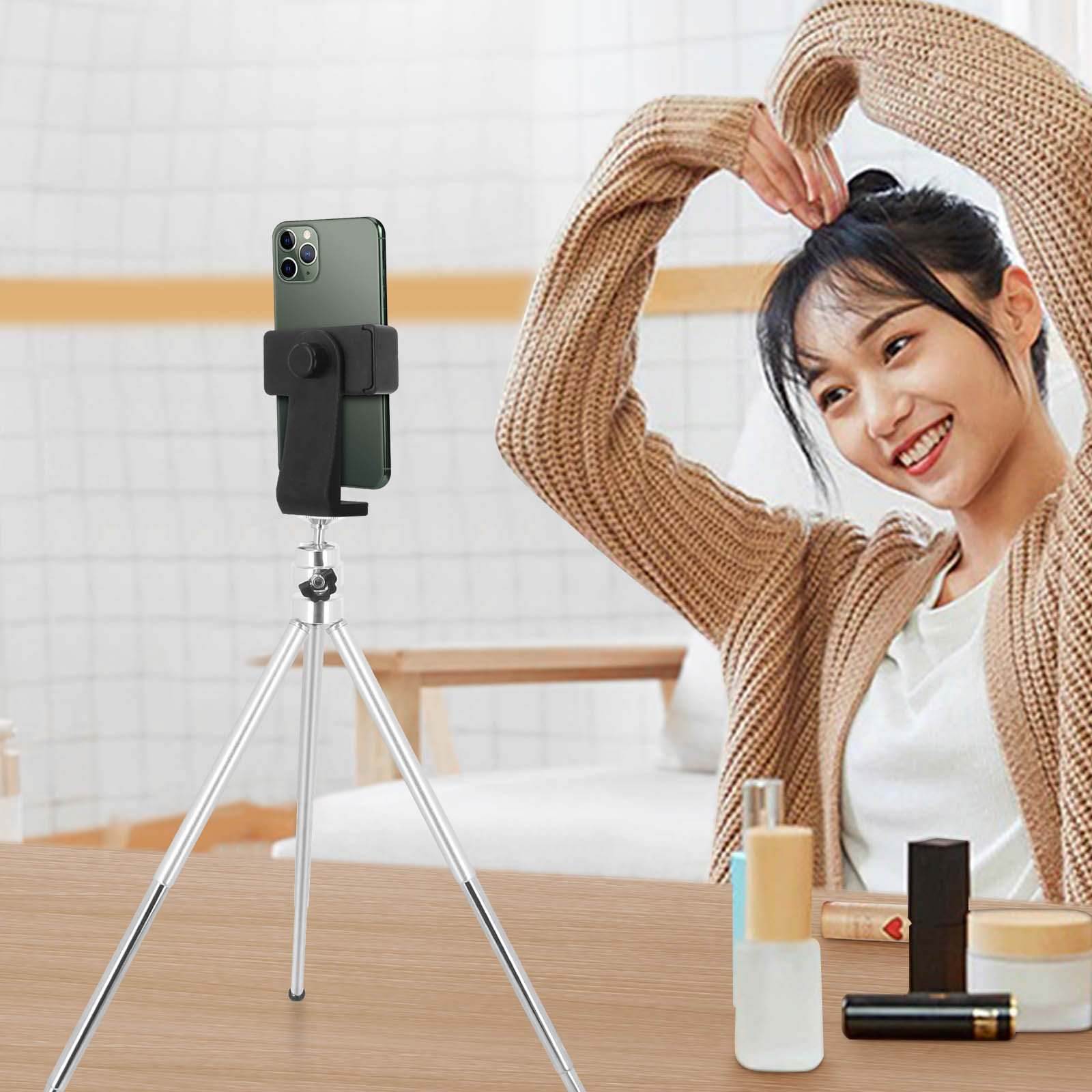 Mujer filmando con smartphone en trípode. Está haciendo un corazón con las manos.