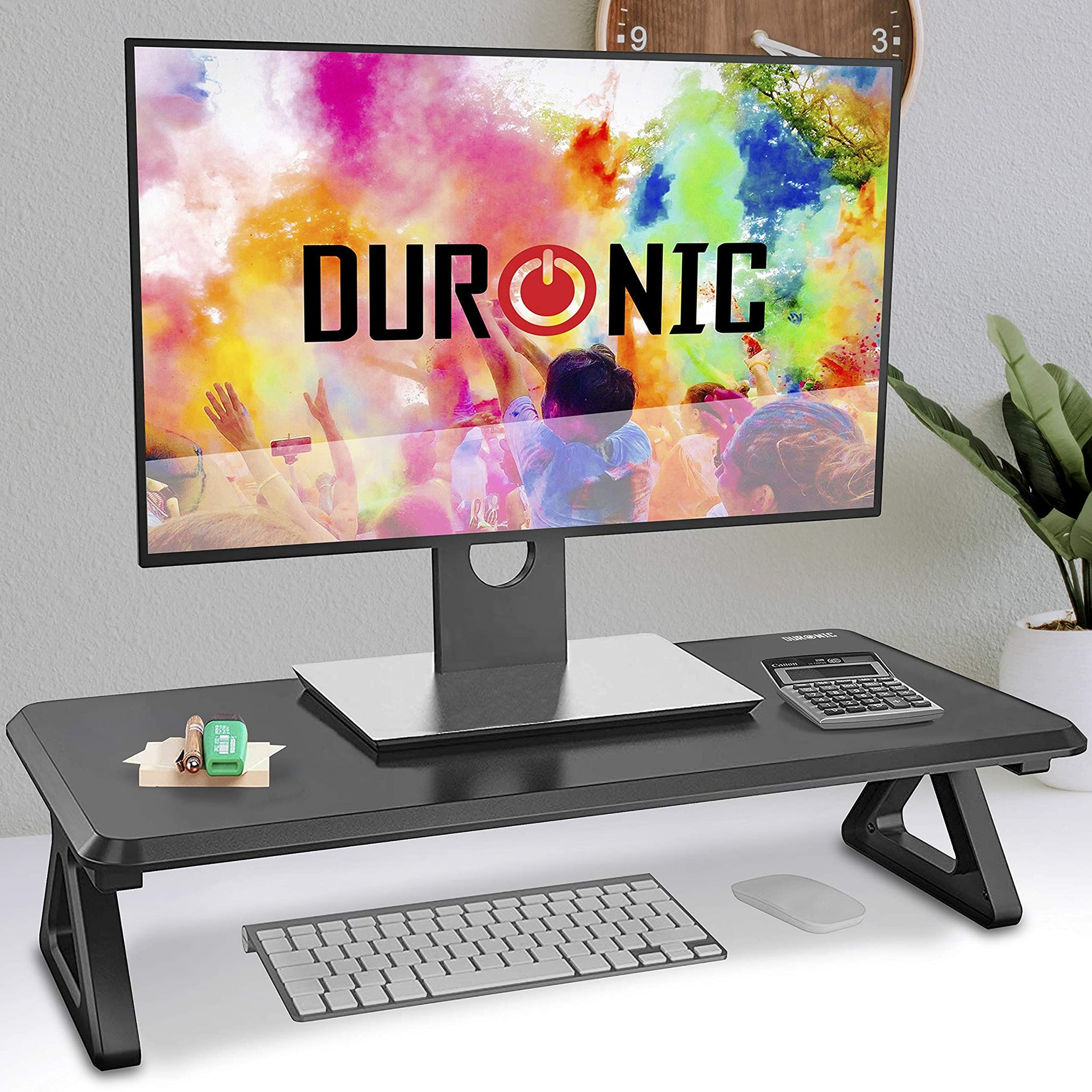 Ein Monitor auf einem schwarzen Ständer auf einem schwarzen Schreibtisch mit Tastatur und Maus.