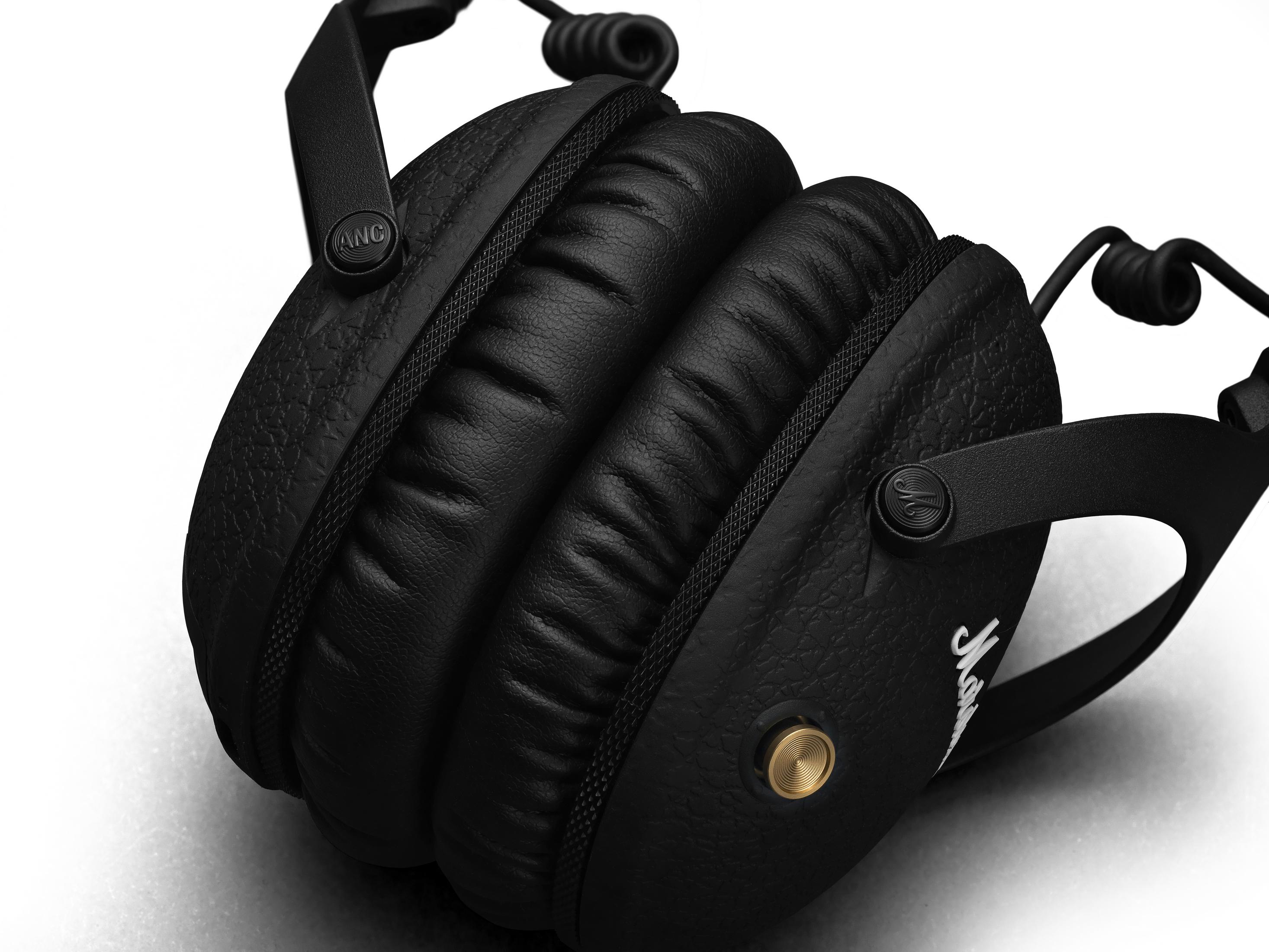 Schwarze Marshall-Kopfhörer mit Leder-Ohrmuscheln. Auf einer Ohrmuschel ist ein goldener Knopf.