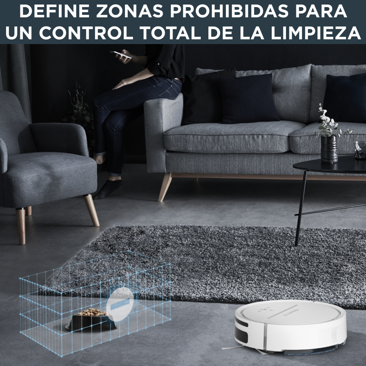 Robot sprzątający Roomba na szarej macie, z sofą, osobą i tekstem.