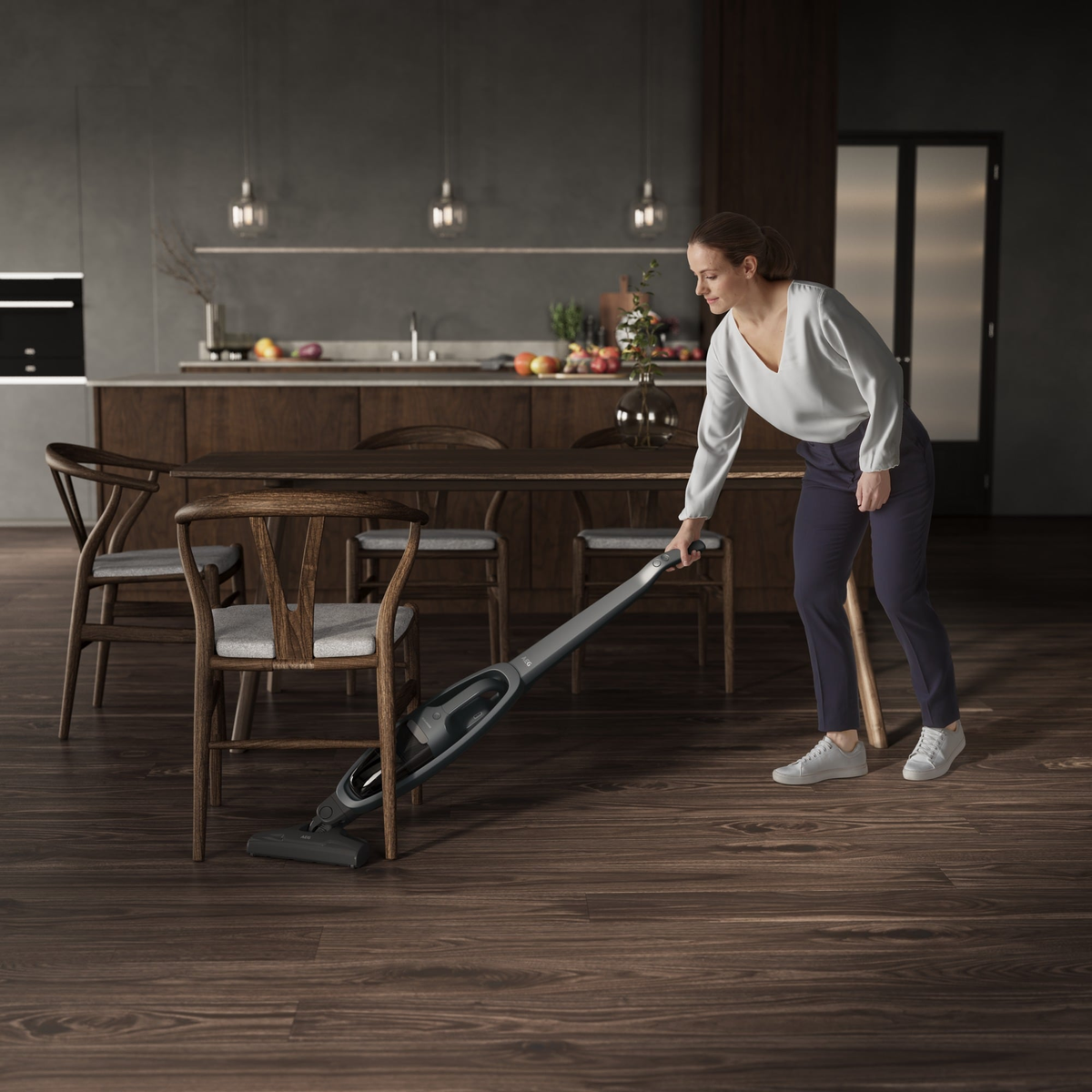 Eine Frau, die in einem Esszimmer einen Holzboden mit einem kabellosen Staubsauger saugt.