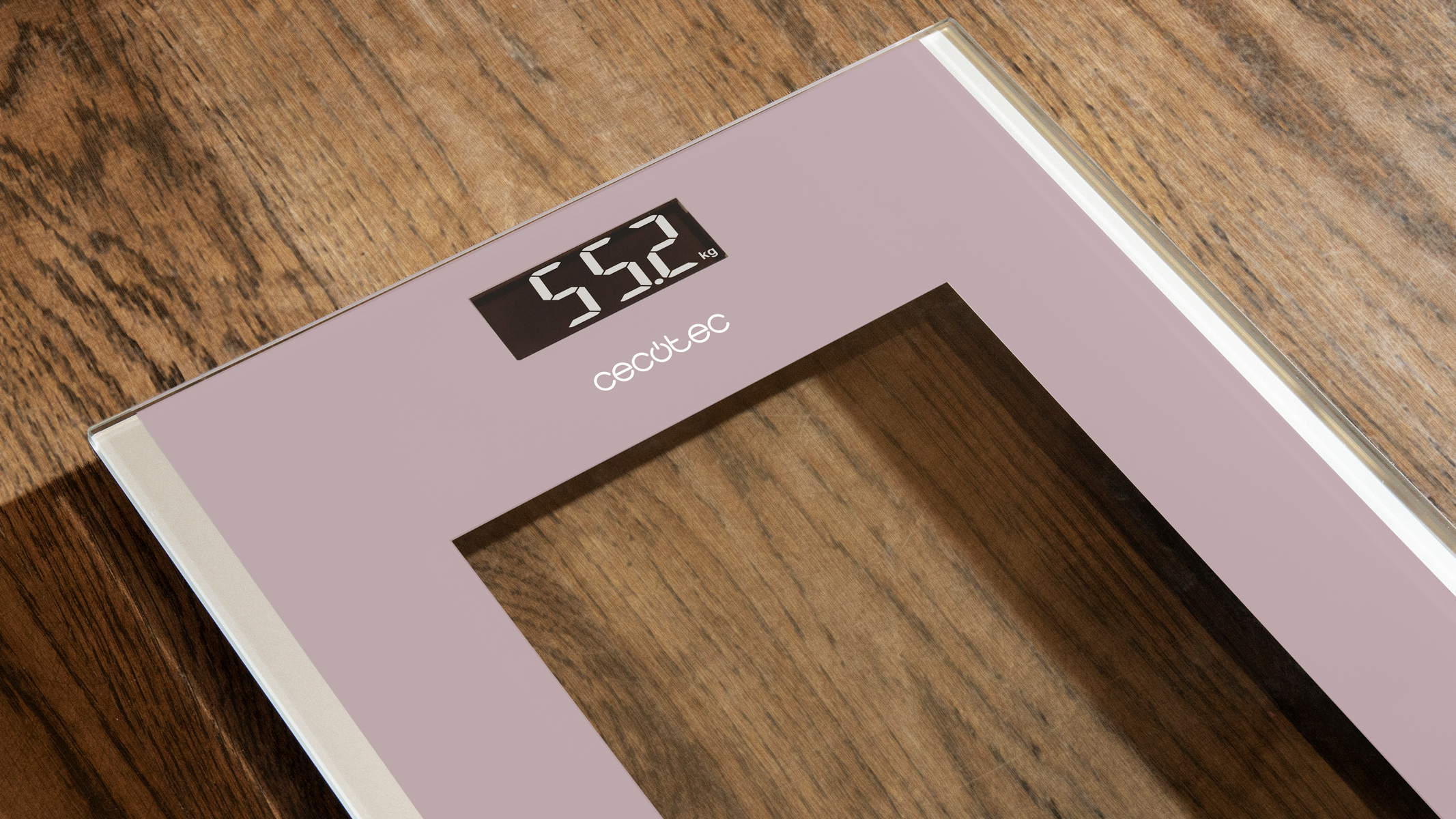 Waga cyfrowa pokazuje 55,2 kg. Waga jest jasnoróżowa, leży na drewnianej powierzchni.
