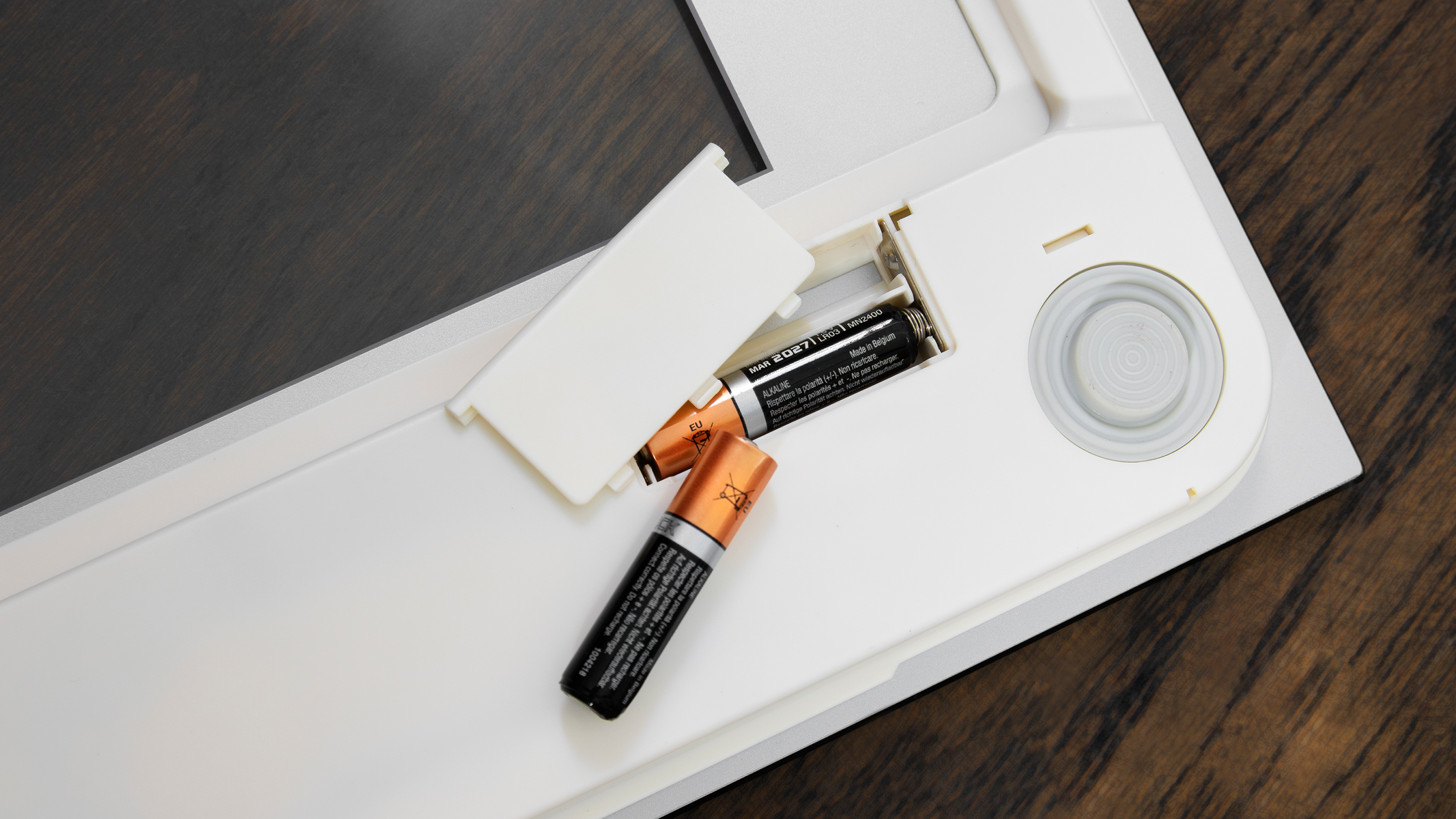 Baterie w komorze wagi, biała ramka, na drewnianej powierzchni.