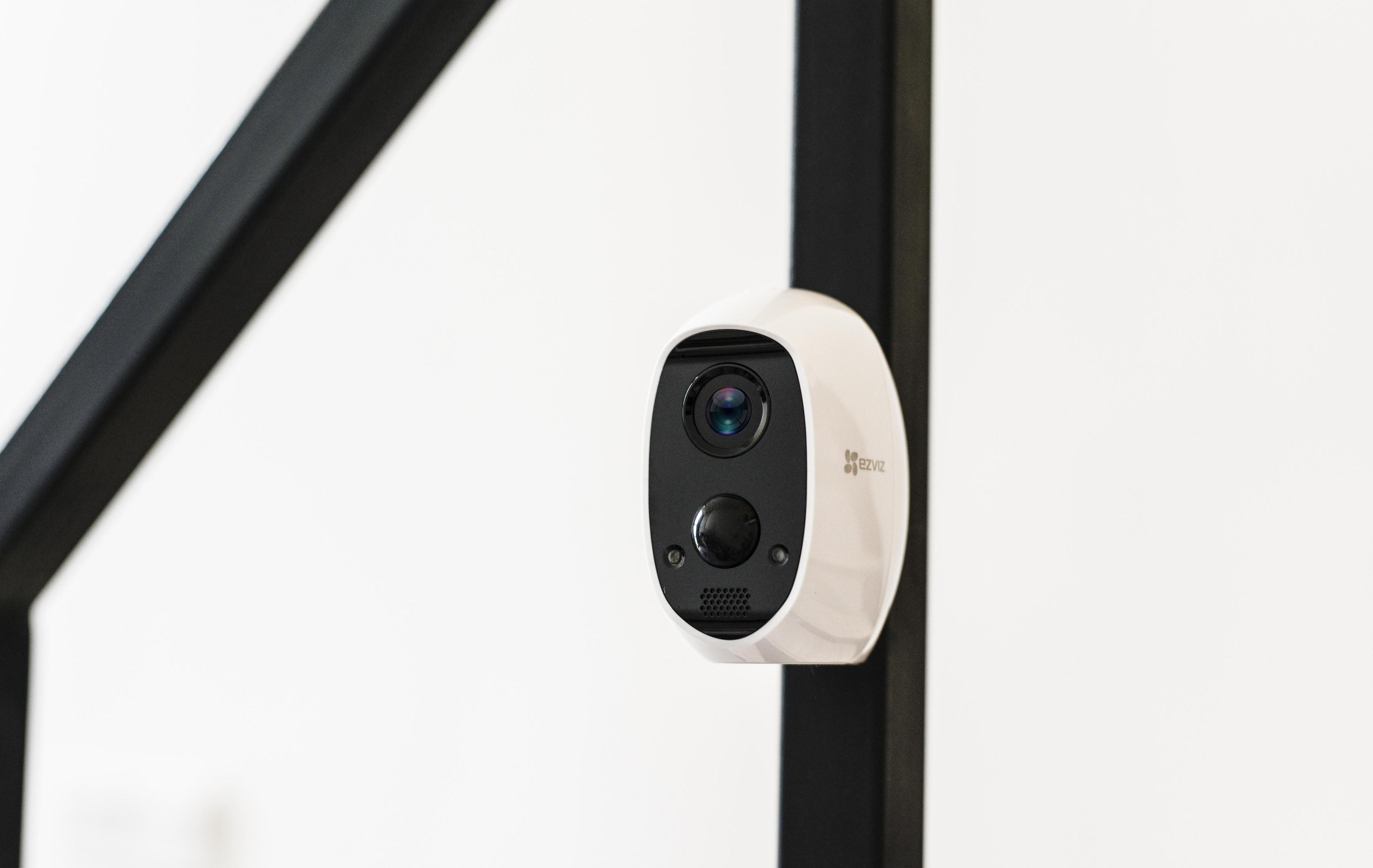 Biała kamera bezpieczeństwa na białej ścianie.