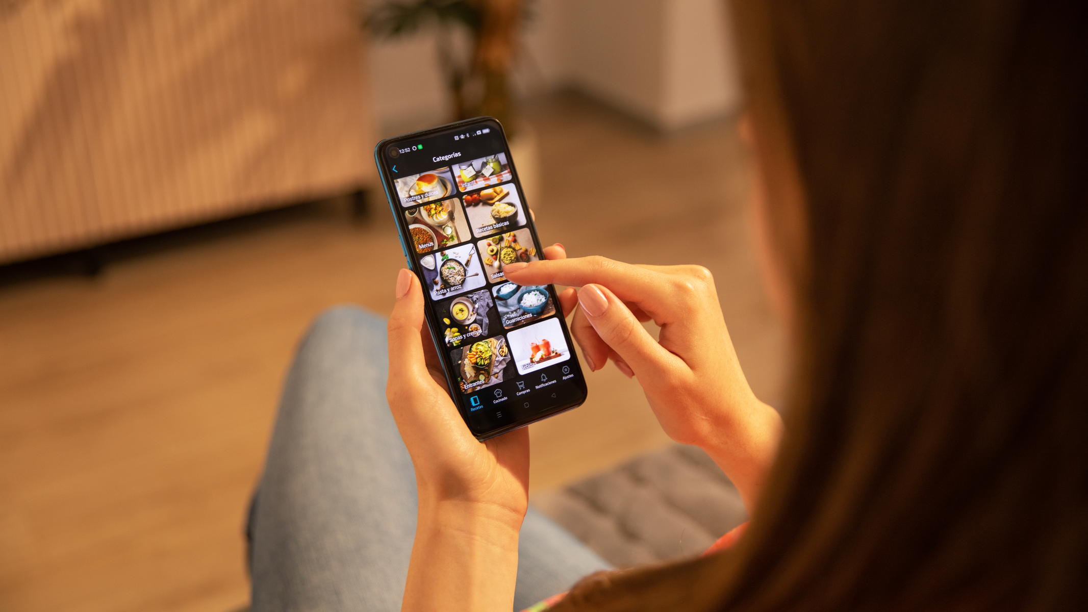 Persona usando un teléfono con una app de comida en la pantalla.