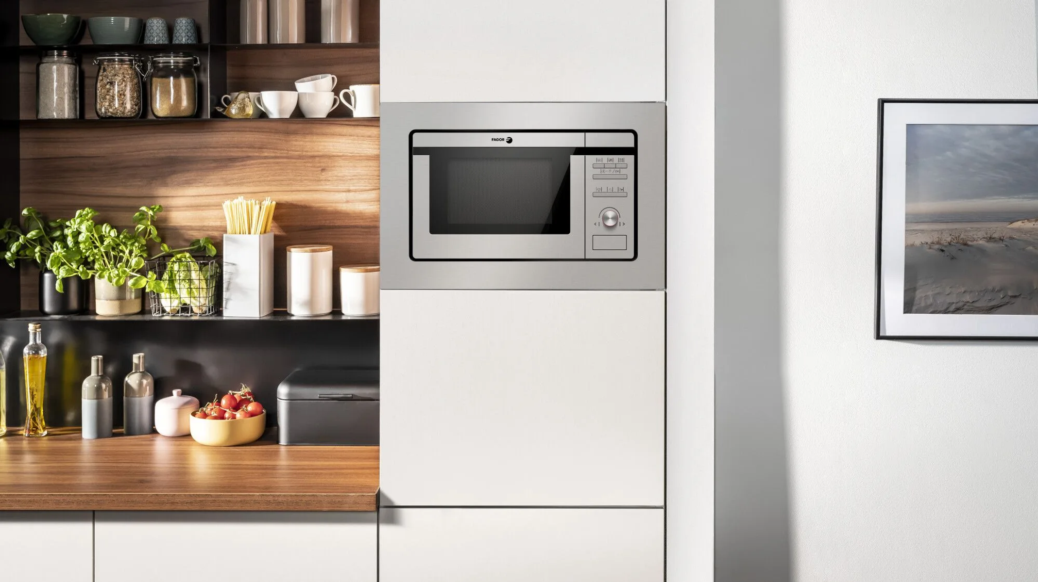 Un horno microondas empotrado en un armario de cocina, con encimera de madera.