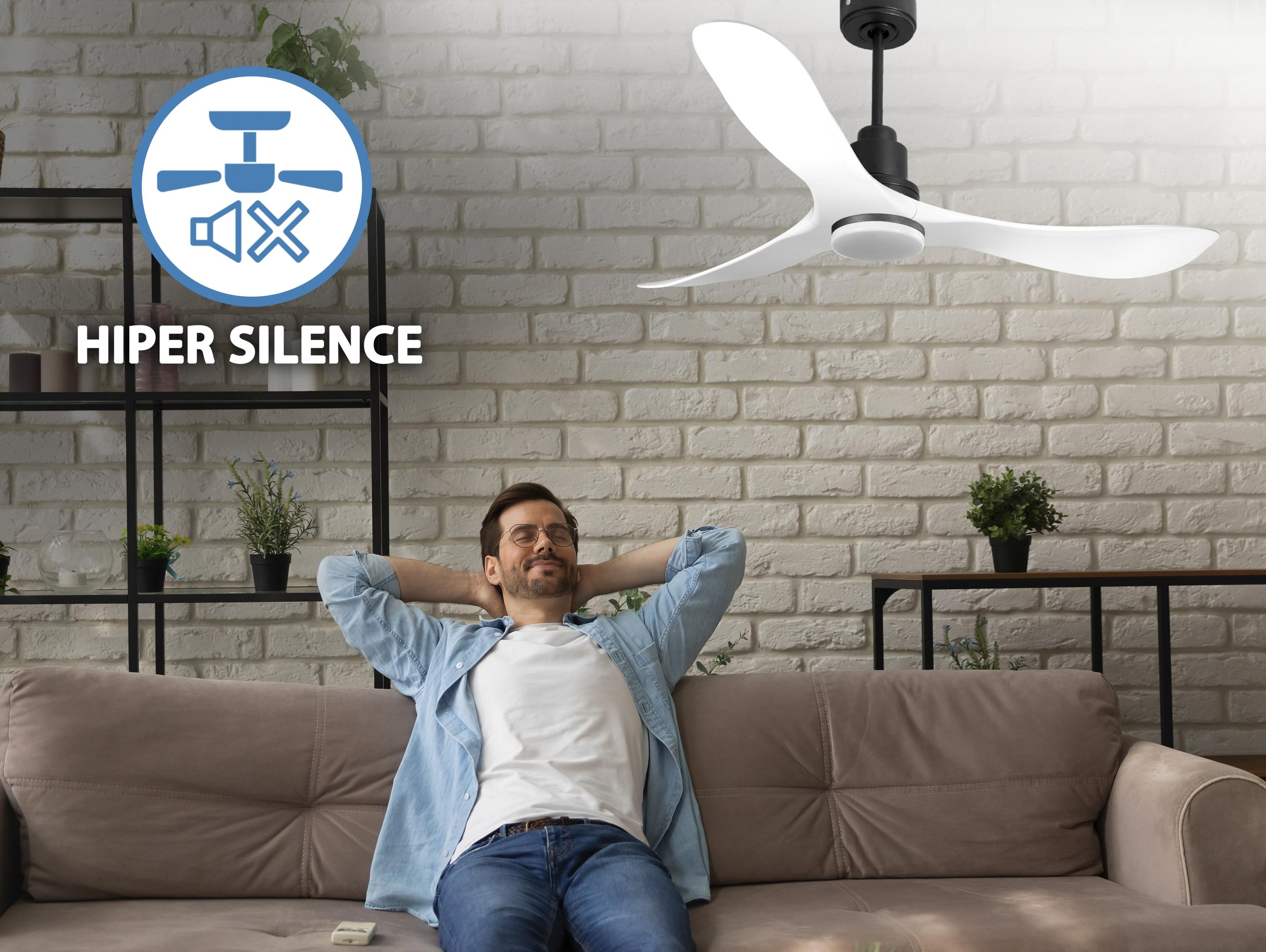 Un hombre se relaja en un sofá bajo un ventilador de techo blanco y negro. El texto "Hiper Silence" es visible.