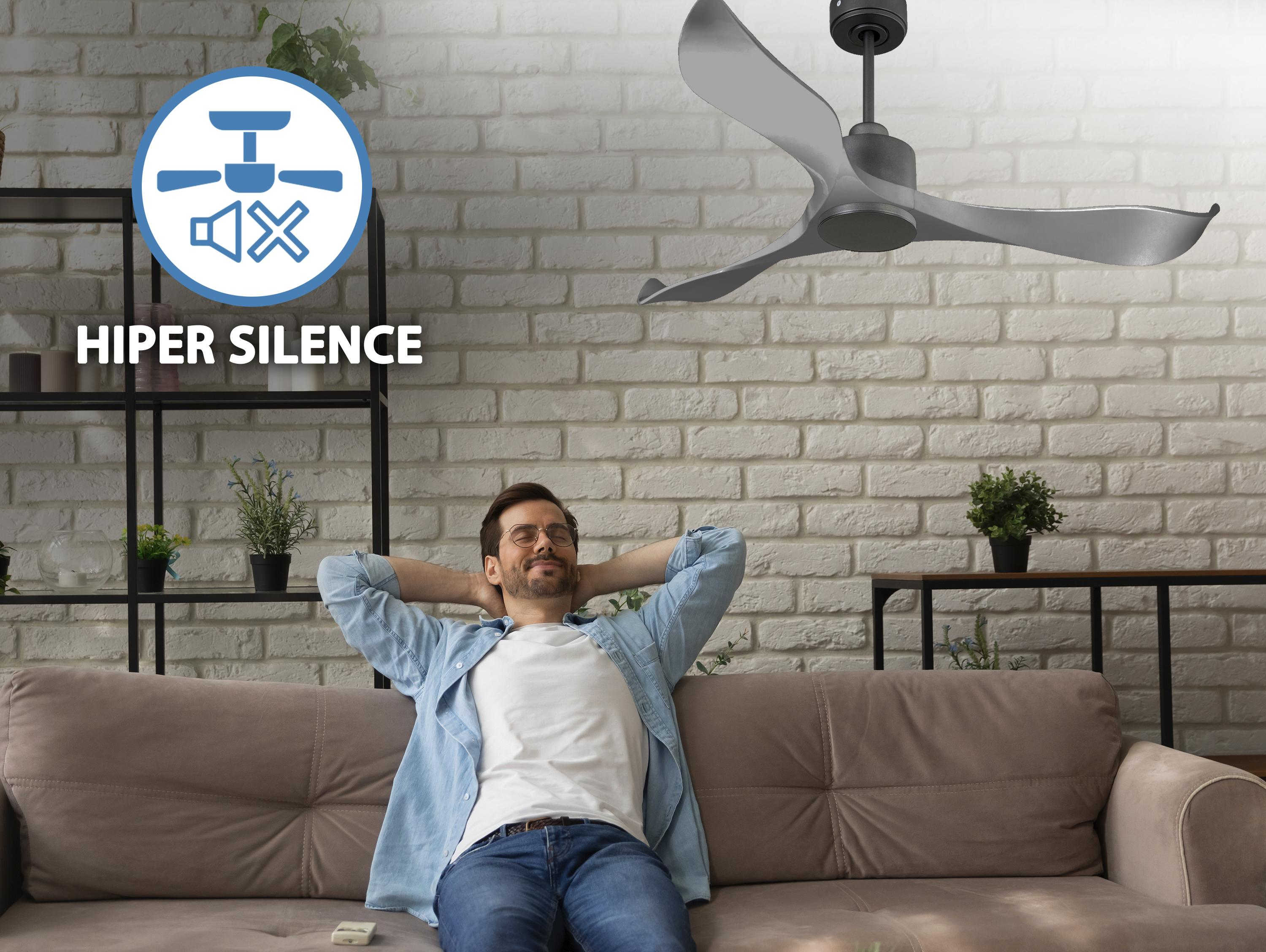 Un hombre se relaja en un sofá, un ventilador de techo está encima de él.