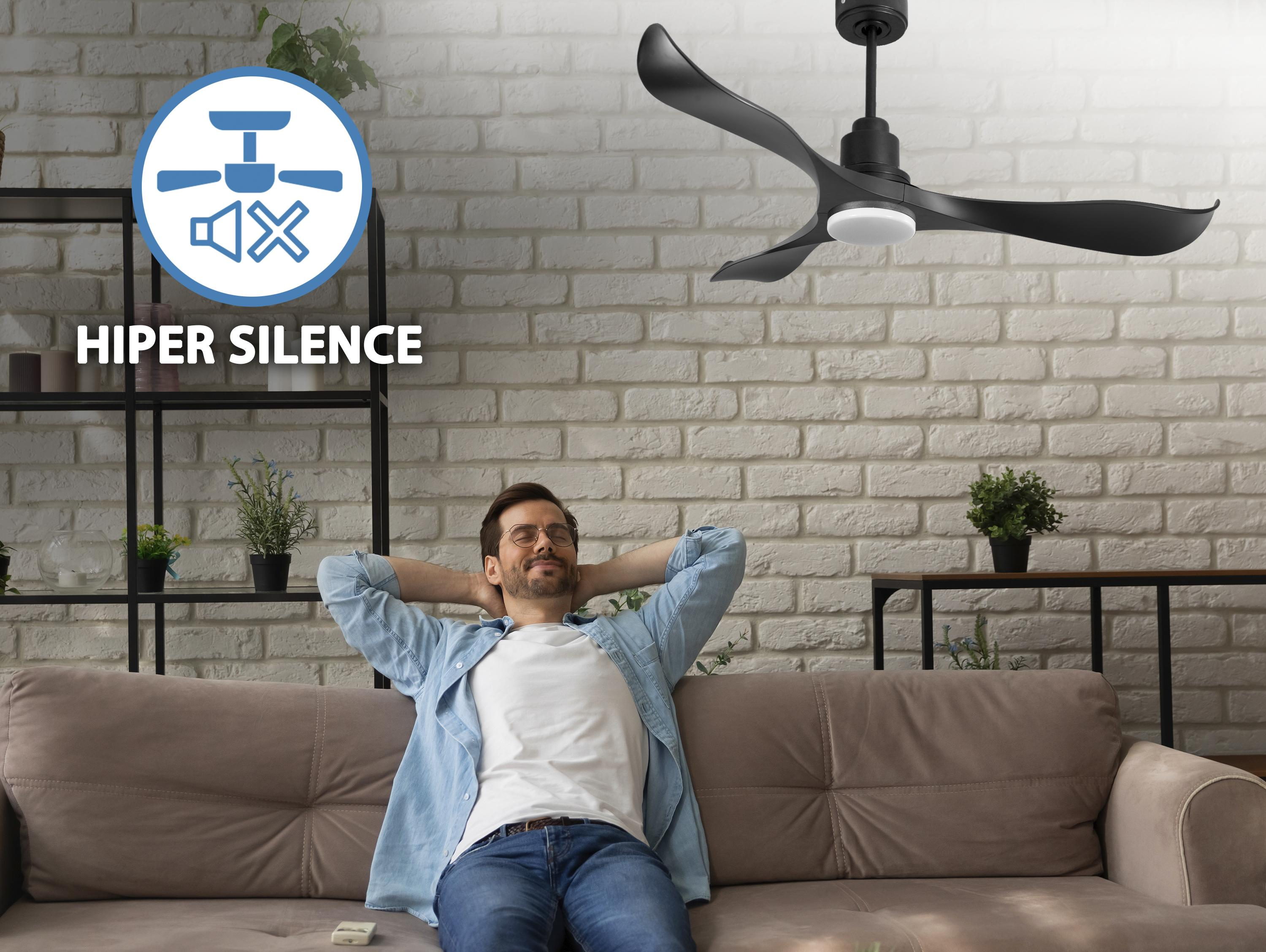 Hombre relajándose en un sofá bajo un ventilador de techo negro. Texto: 'HIPER SILENCE'.