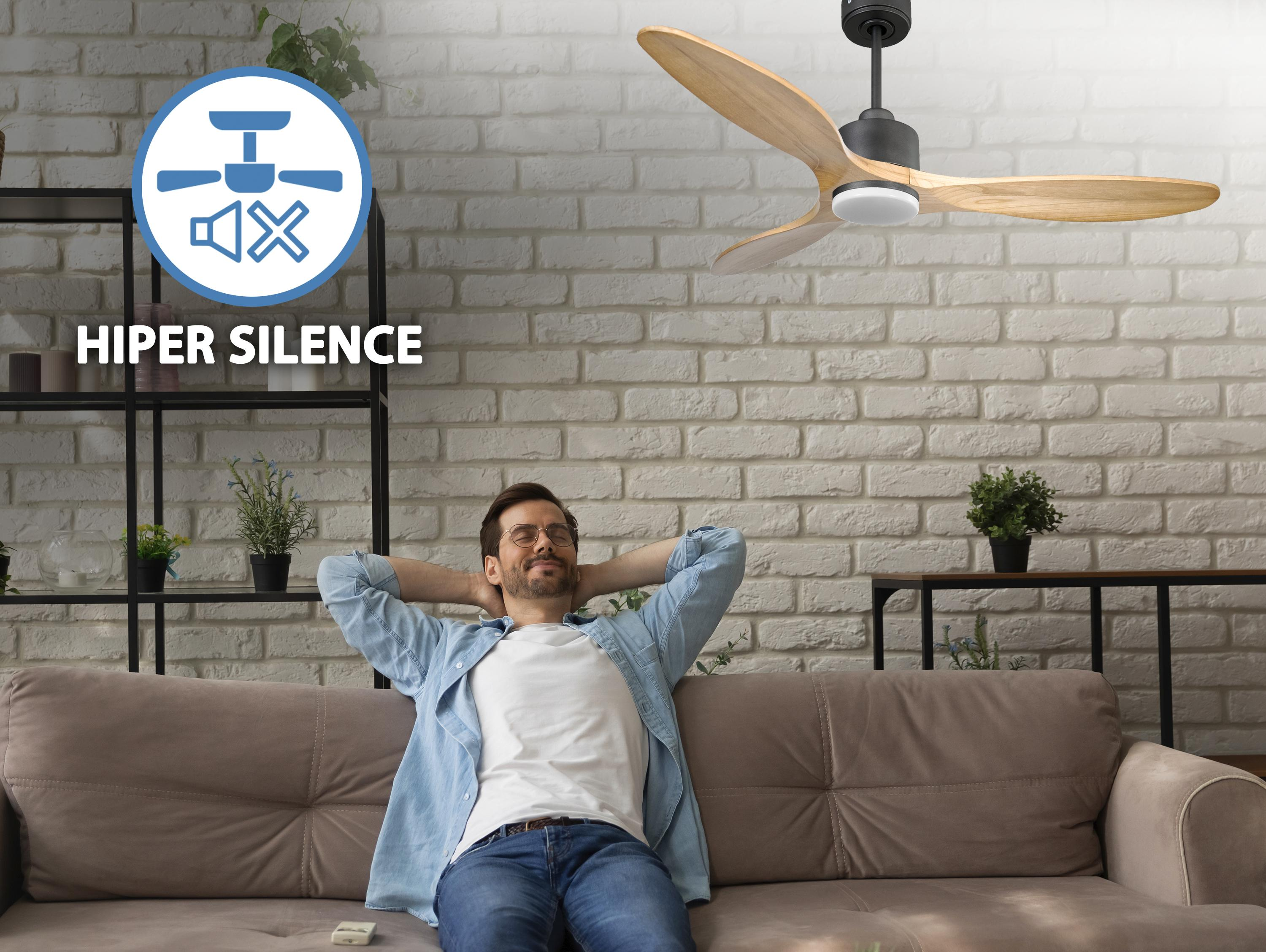 Un hombre relajándose en un sofá, con un ventilador de techo encima y un símbolo de silencio. El texto dice: