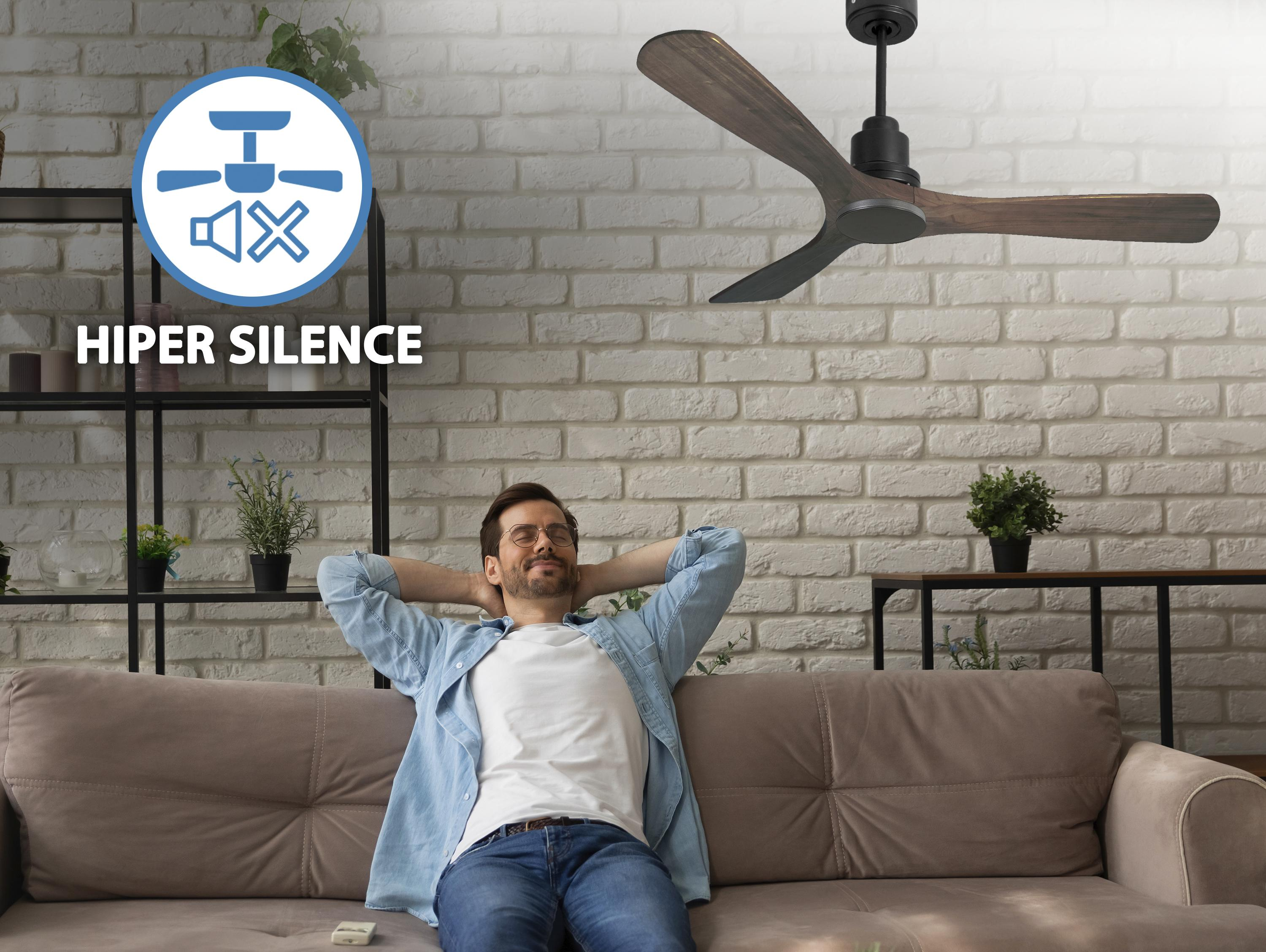 Hombre sentado en un sofá relajándose, con un ventilador de techo y un icono de silencio.