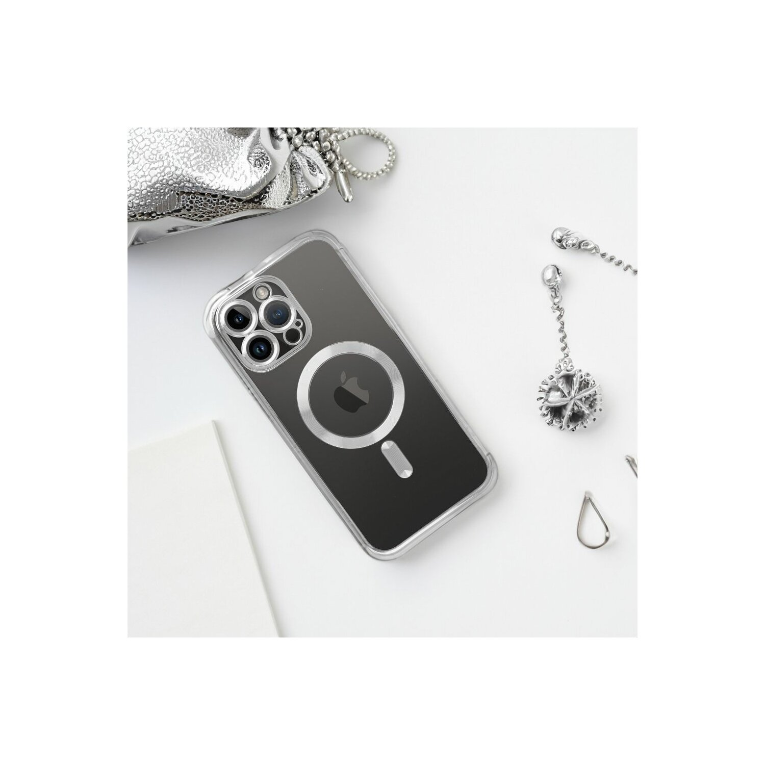 Custodia del telefono, accessori e borsa su una superficie bianca. iPhone visibile.