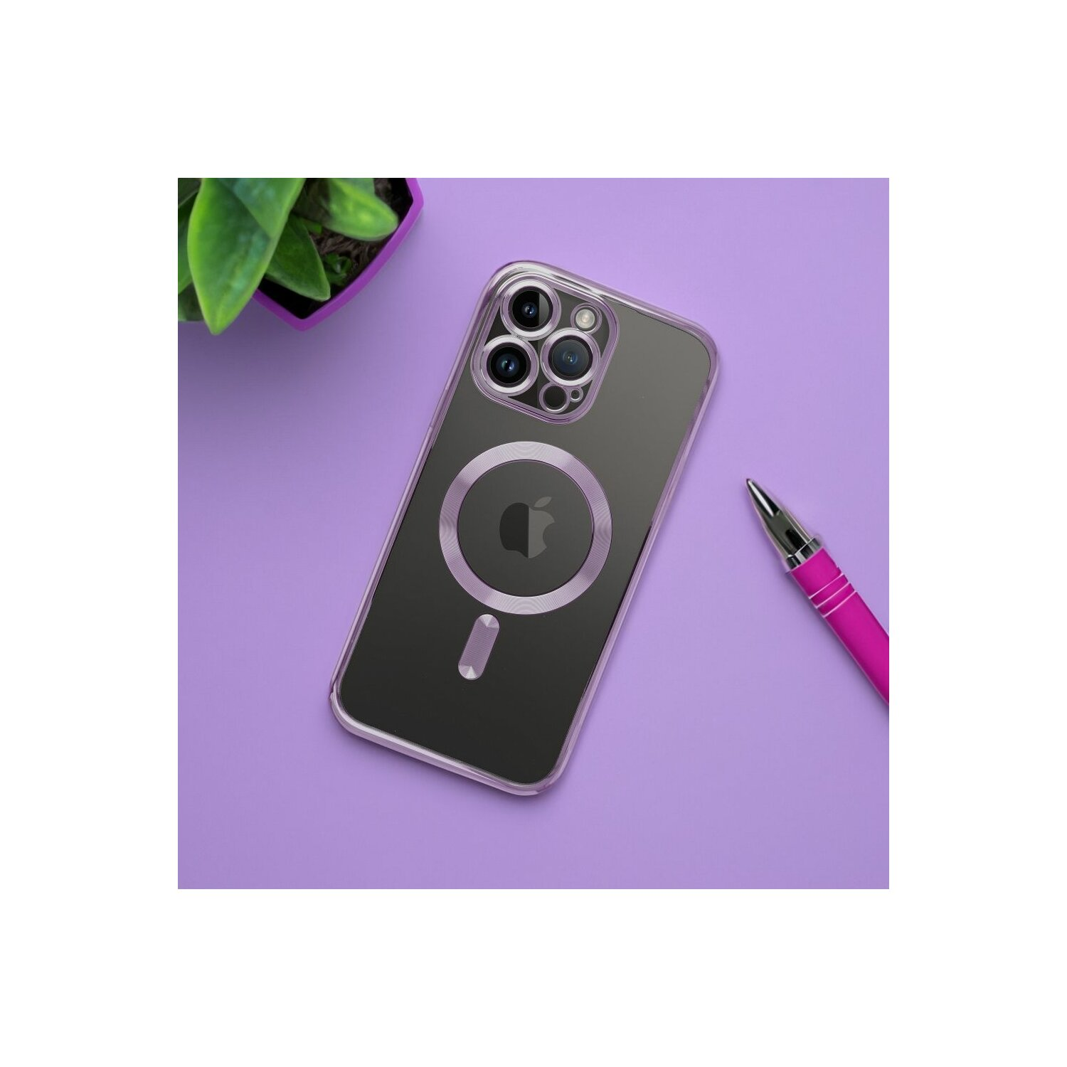 Una custodia trasparente per telefono con il logo Apple su una superficie viola, con una pianta e una penna rosa.
