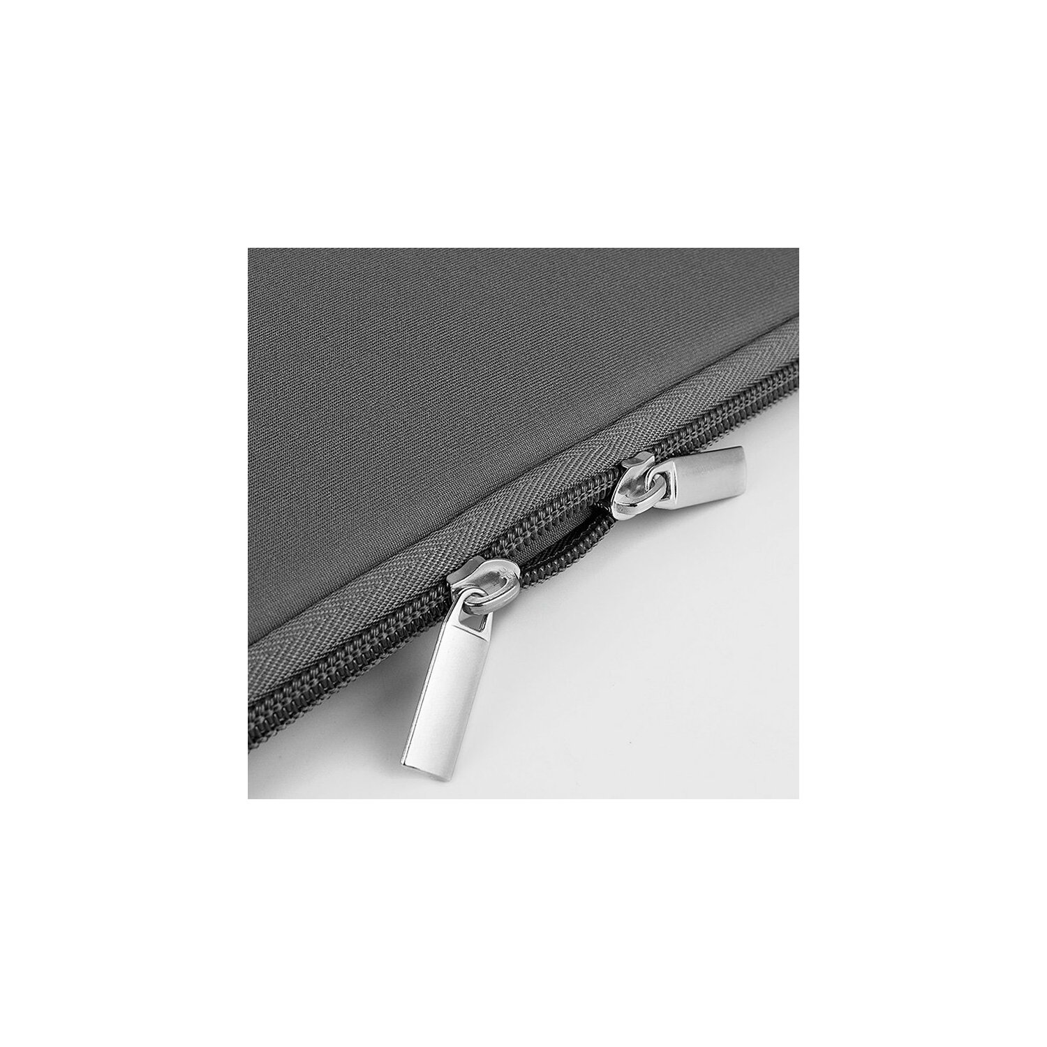Nahaufnahme einer dunkelgrauen Laptoptasche mit Reißverschluss und silbernen Reißverschlusszippern. Die Reißverschlüsse sind geöffnet.