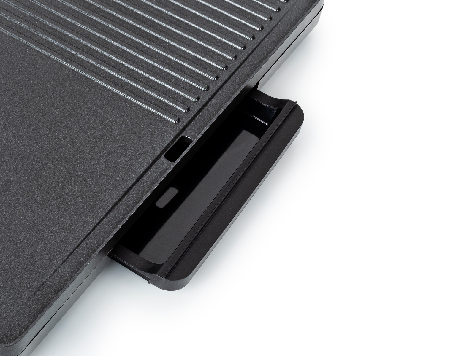 Schwarze Grillplatte mit Abtropfschale. Geriffelte Kochfläche. Weißer Hintergrund.