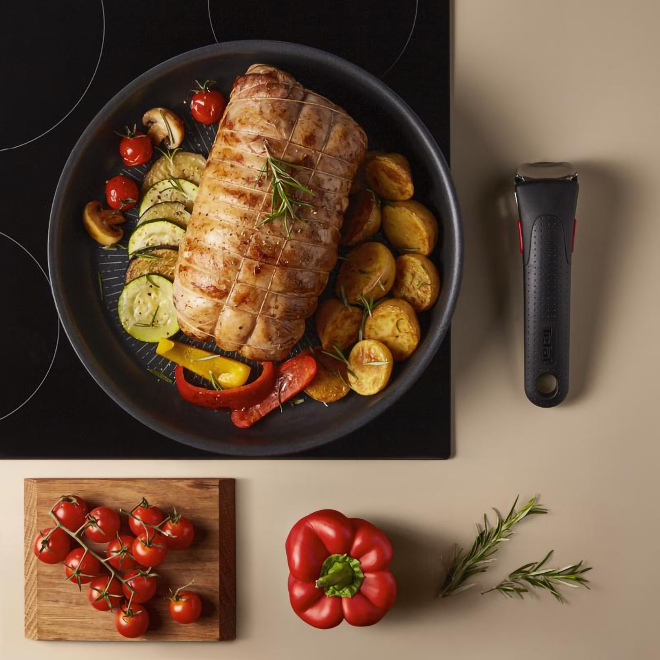 Draufsicht auf eine Pfanne mit gebratenem Fleisch, Gemüse und Griff. Serviert mit Tomaten, Paprika und Kräutern.