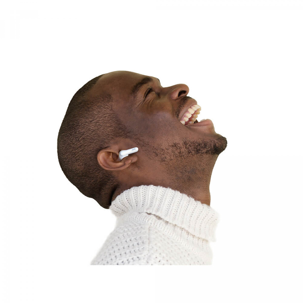 Mężczyzna w białym swetrze i słuchawką w uchu. Patrzy w górę i śmieje się.