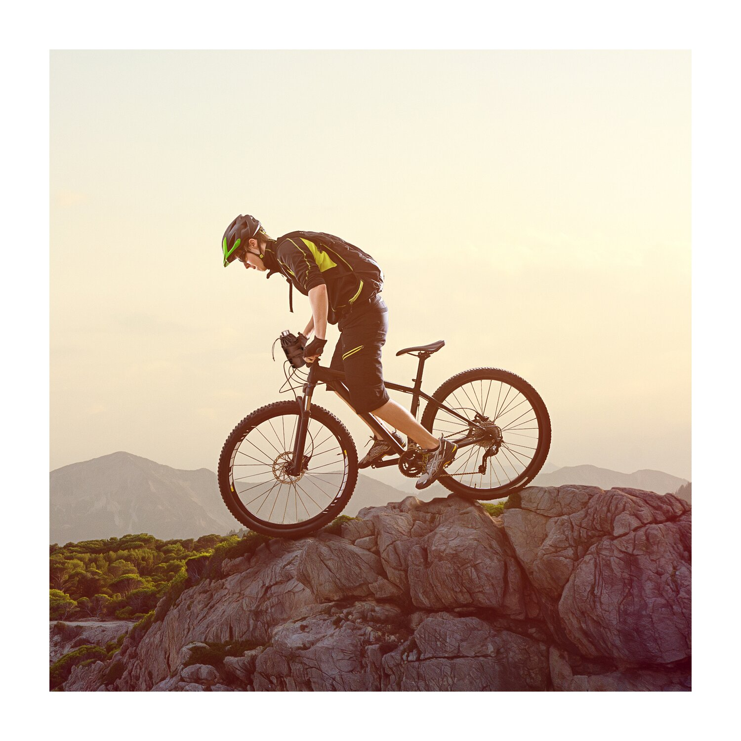 Ein Radfahrer in Aktion, der auf felsigem Gelände mit einem Mountainbike fährt.