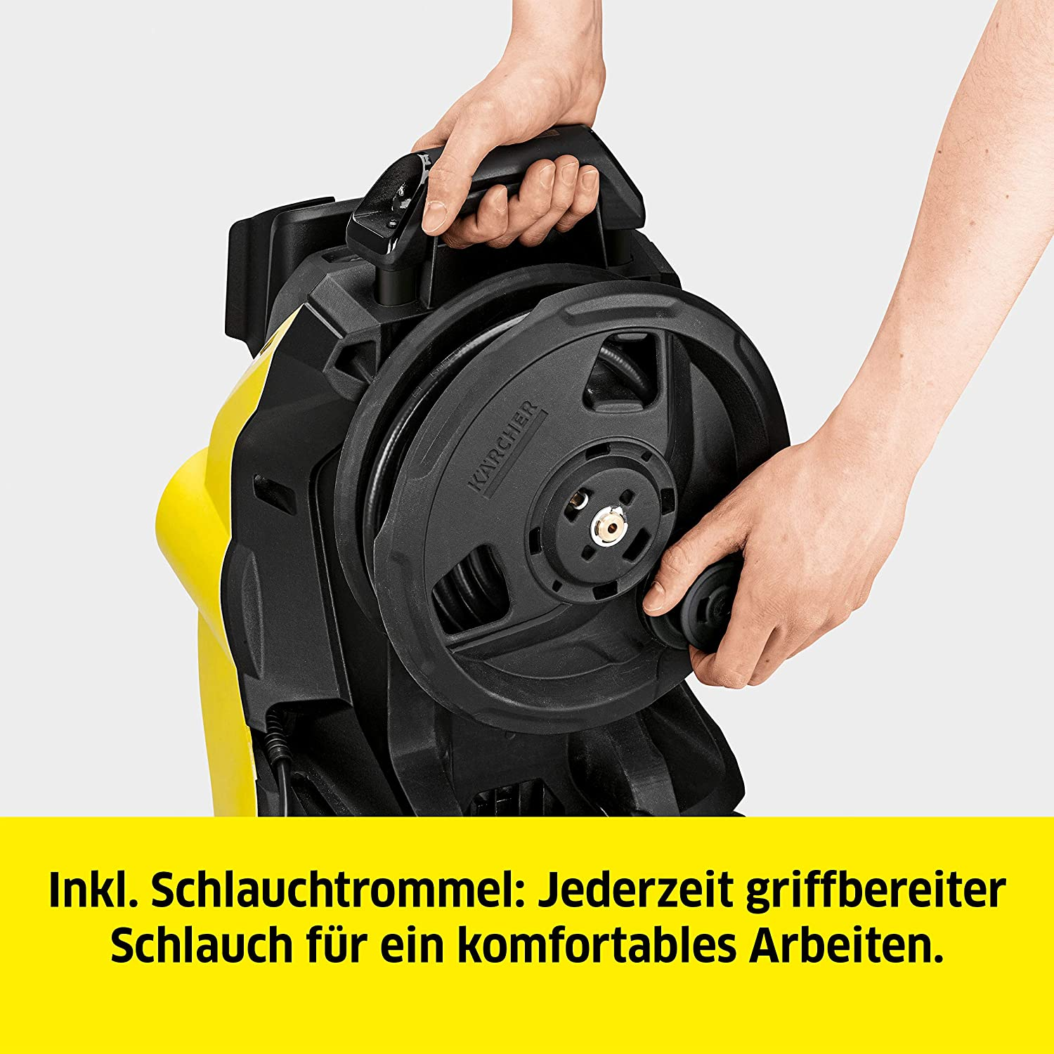 Una persona usando una hidrolavadora Karcher amarilla.