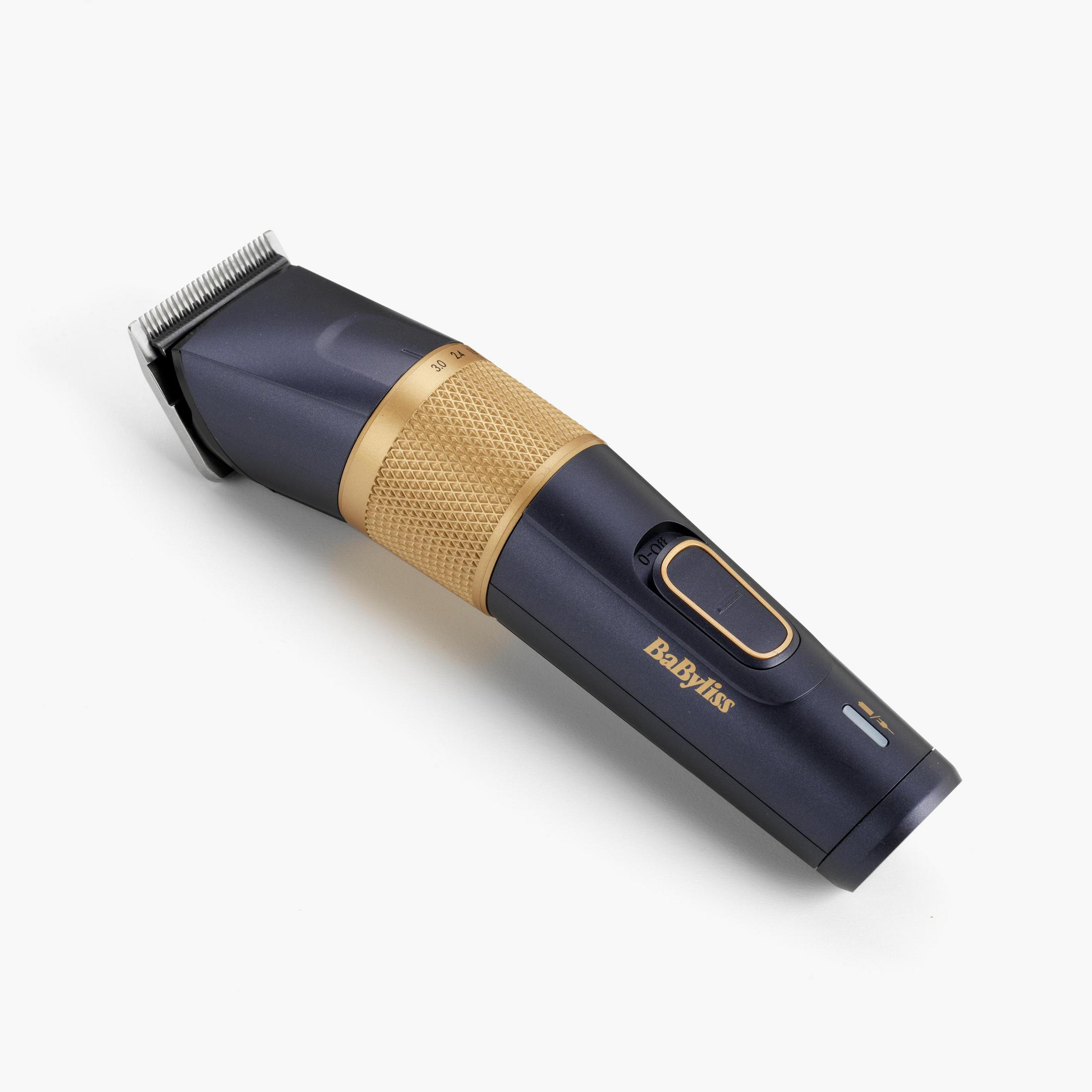 Czarna i złota maszynka do włosów, pod kątem, z pokrętłem i marką 'BabyLiss'.