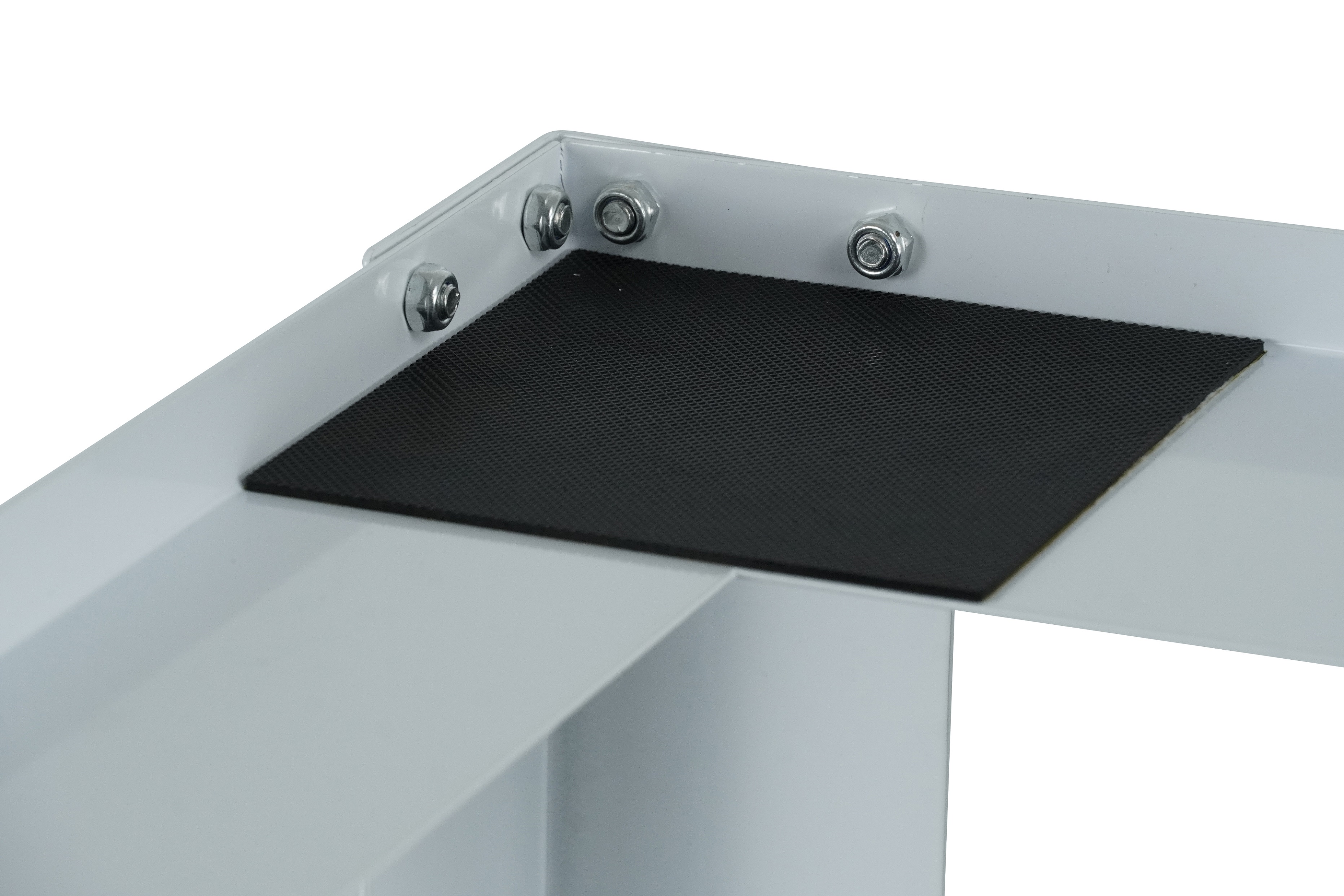 Close-up of a white metal corner with bolts. A black square pad is placed inside the corner.