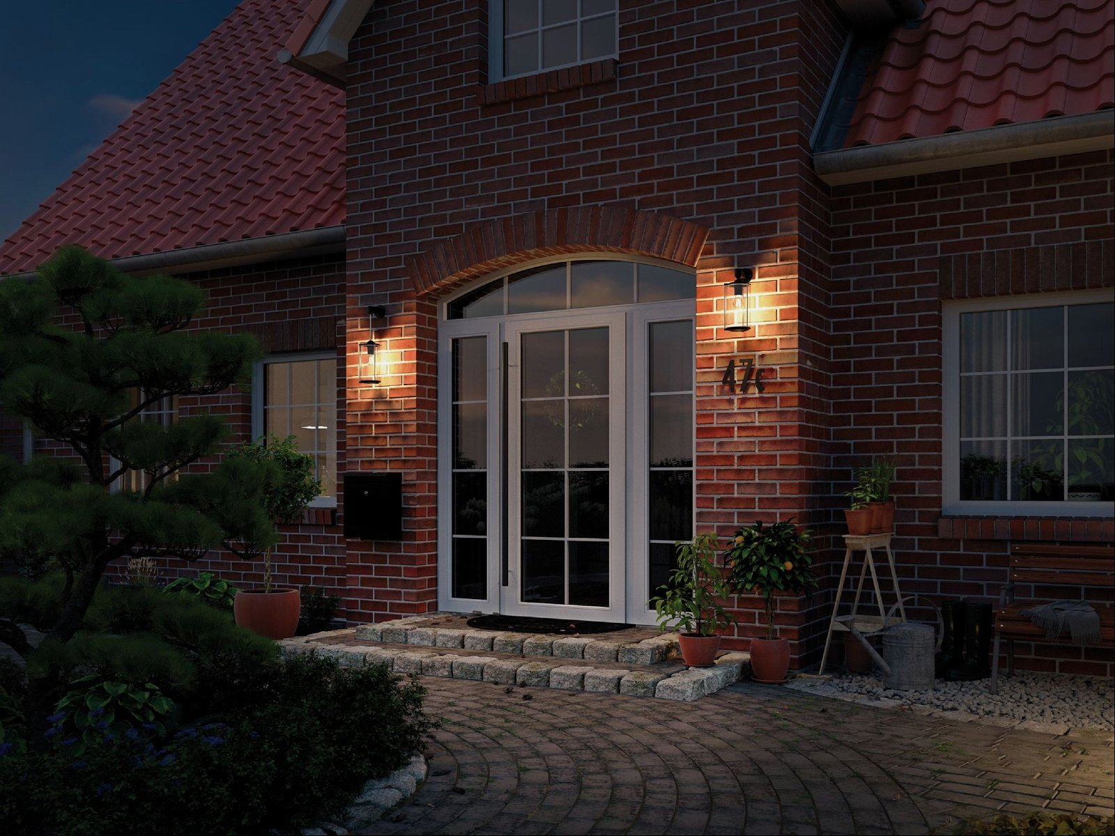 Dom z dwiema lampami ściennymi i włączonymi światłami w nocy.