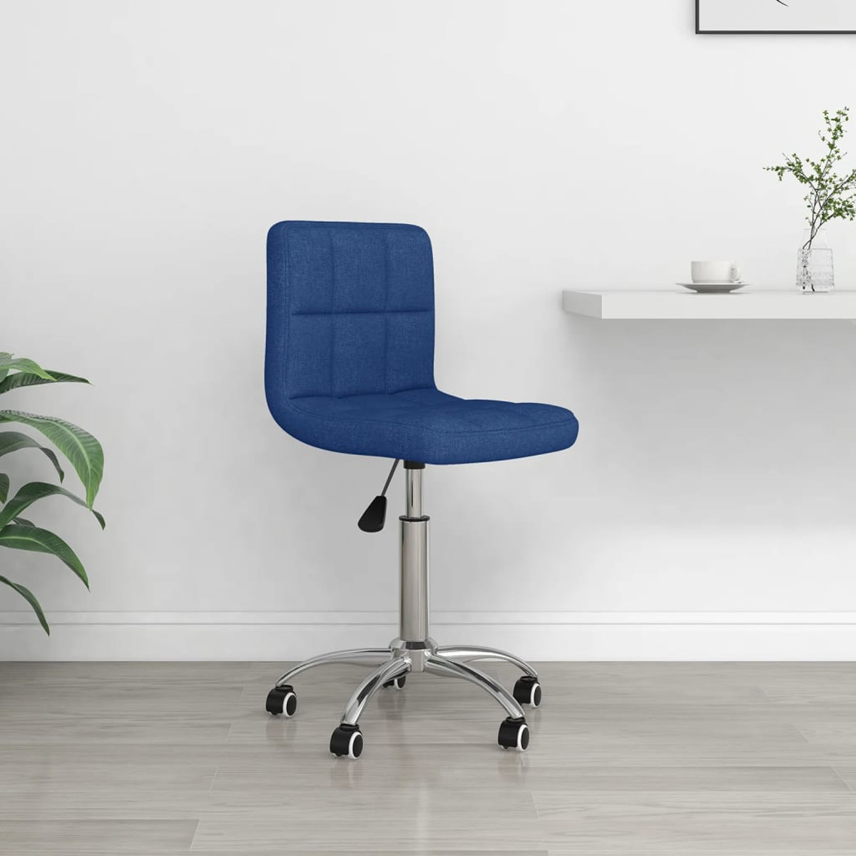 Ein blauer Bürostuhl auf Rollen, vor einer weißen Wand, mit einem kleinen Schreibtisch.