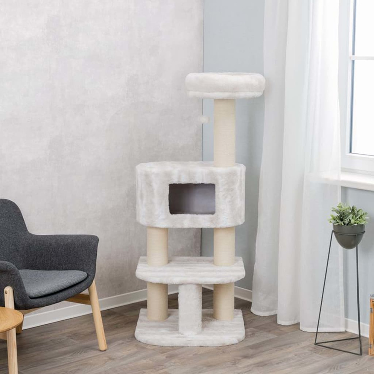 Un albero per gatti alto con più livelli. I pali beige sostengono piattaforme bianche e soffici.