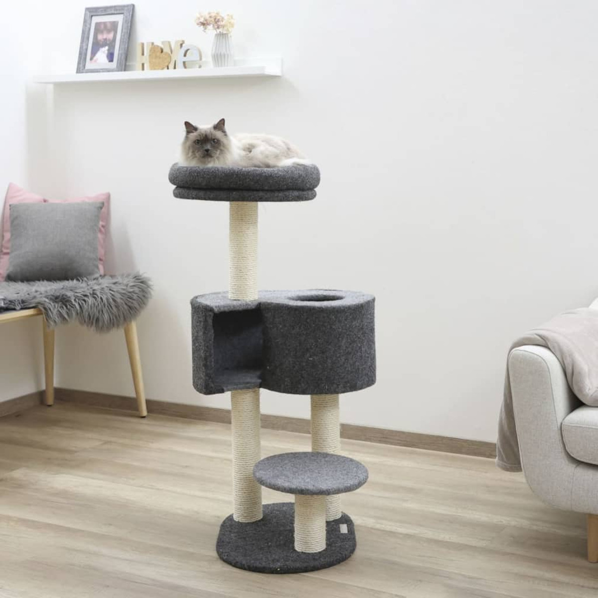 Katzenbaum mit grauen Elementen. Eine Katze ruht oben.