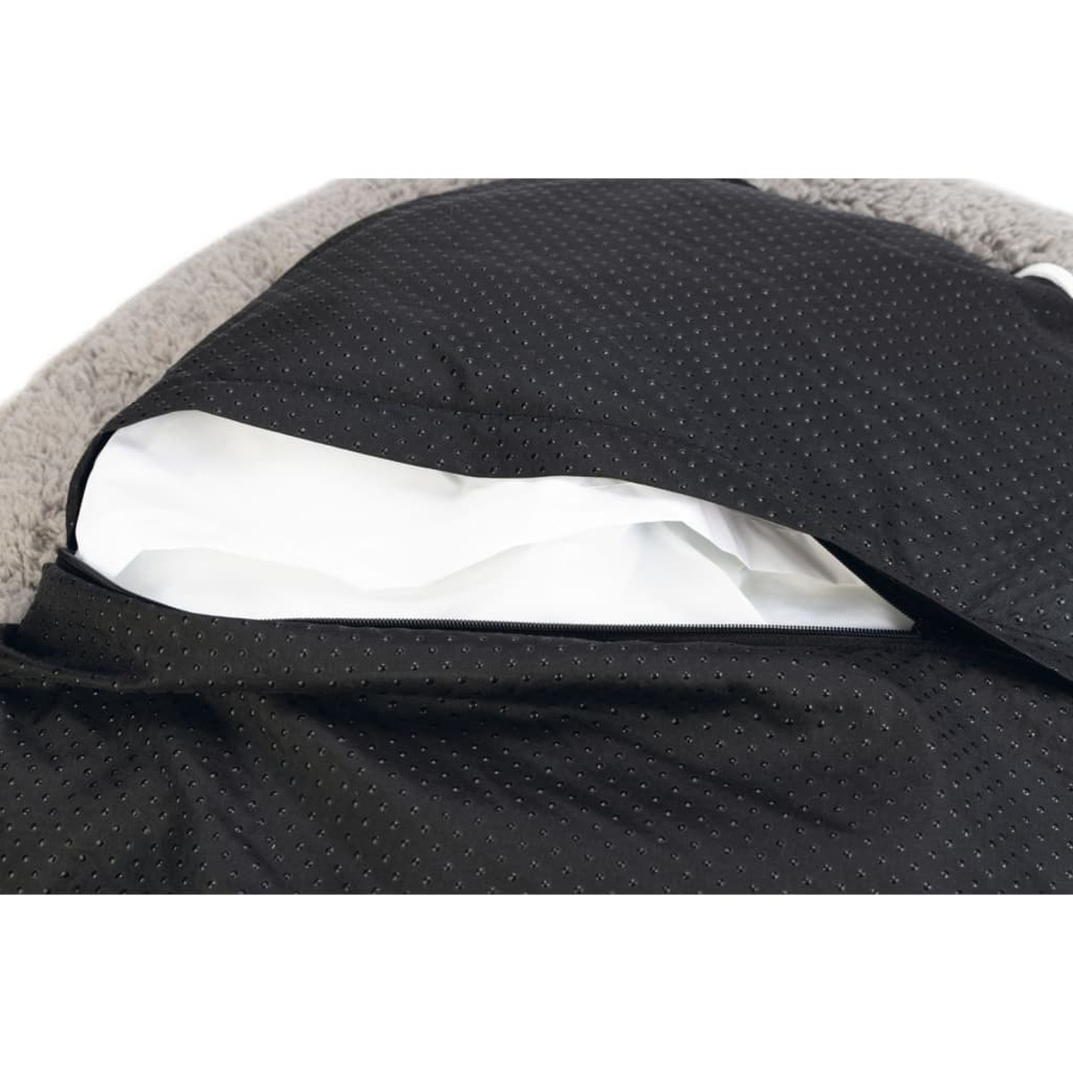 Ein schwarzes Haustierbett mit abnehmbarem Kissen. Das Kissen ist weiß und das Bett hat einen Reißverschluss.