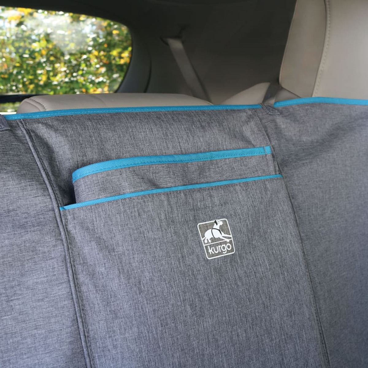 Graue Autositzbezug mit blauer Paspel und Kurgo-Logo, mit Taschen zur Aufbewahrung.
