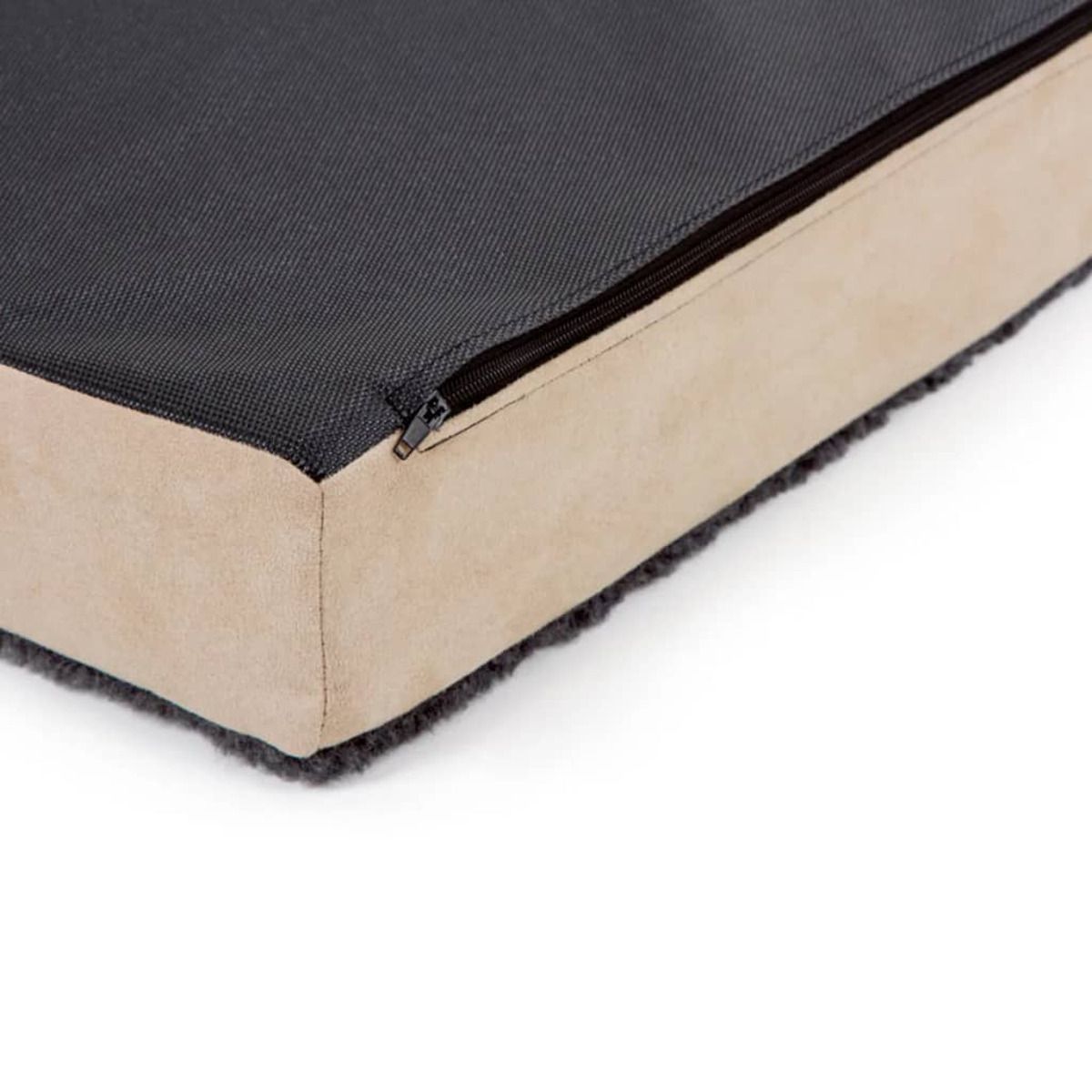 Primo piano del letto per cani, parte superiore in tessuto nero con un lato color beige e una cerniera.