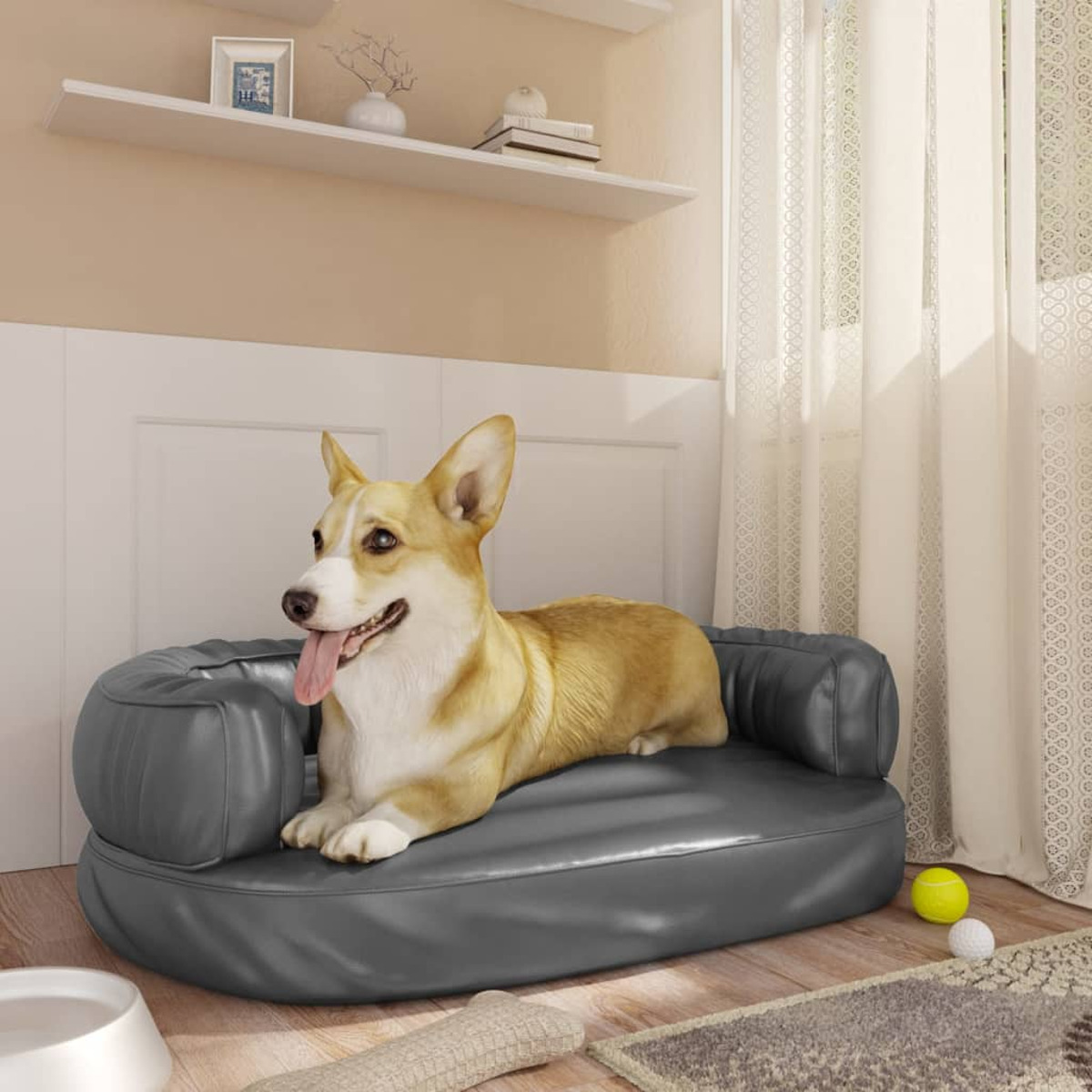 Corgi-Hund liegt auf einem grauen Hundebett. Heller Hintergrund mit Fenster und Regalen.